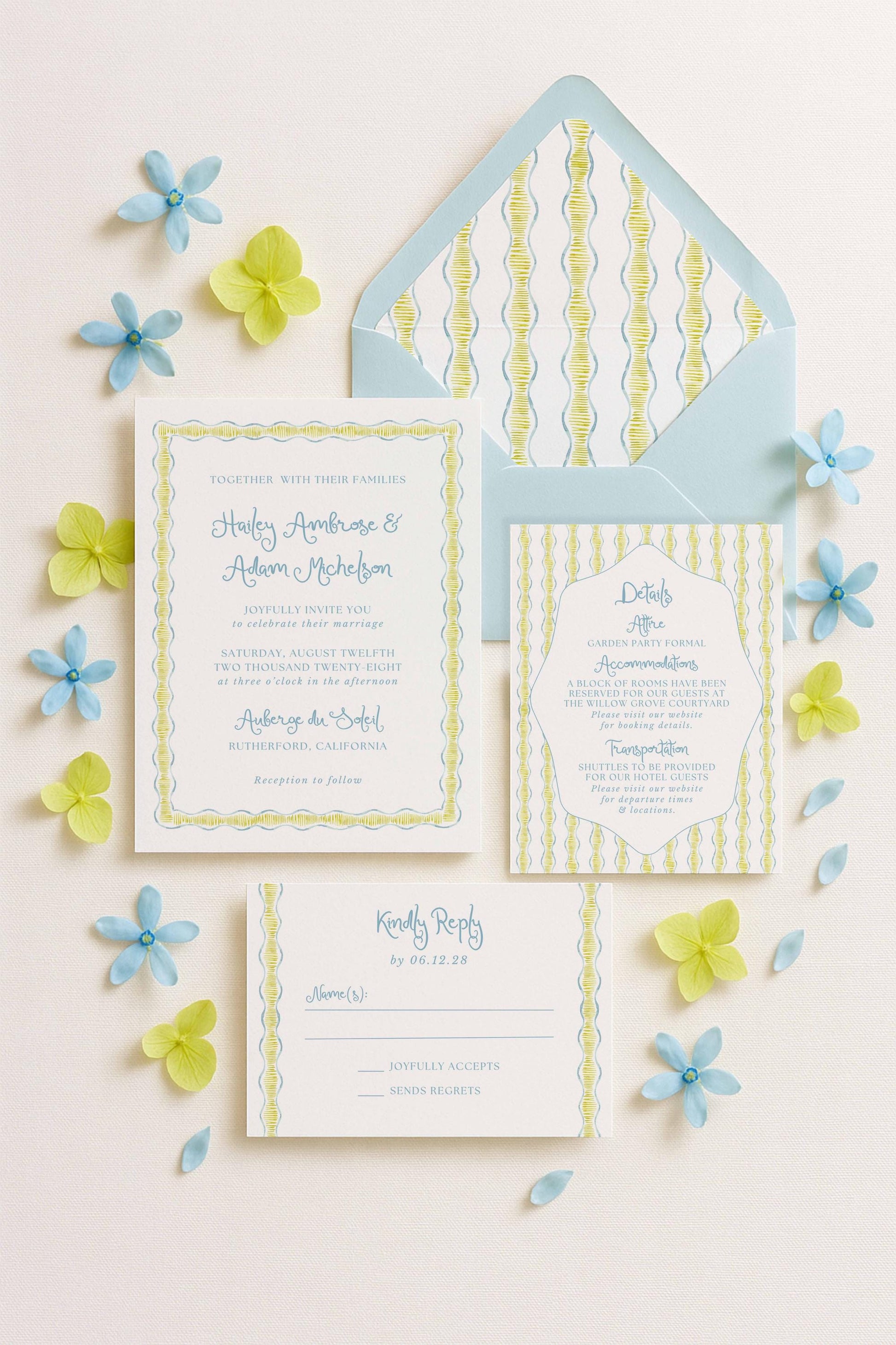a wedding invitation, an envelope, and a response card, all arranged on a white background with blue and yellow flowers scattered around.