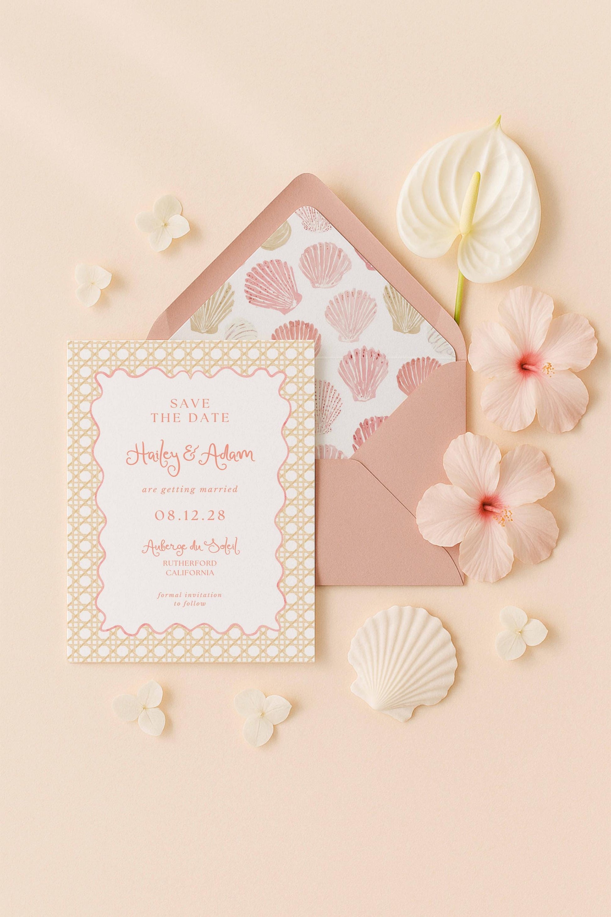 A pink and white wedding invitation card with the text "Save the Date" and "Holly & Adrien are getting married 08.12.28" is surrounded by pink flowers and shells on a peach background.