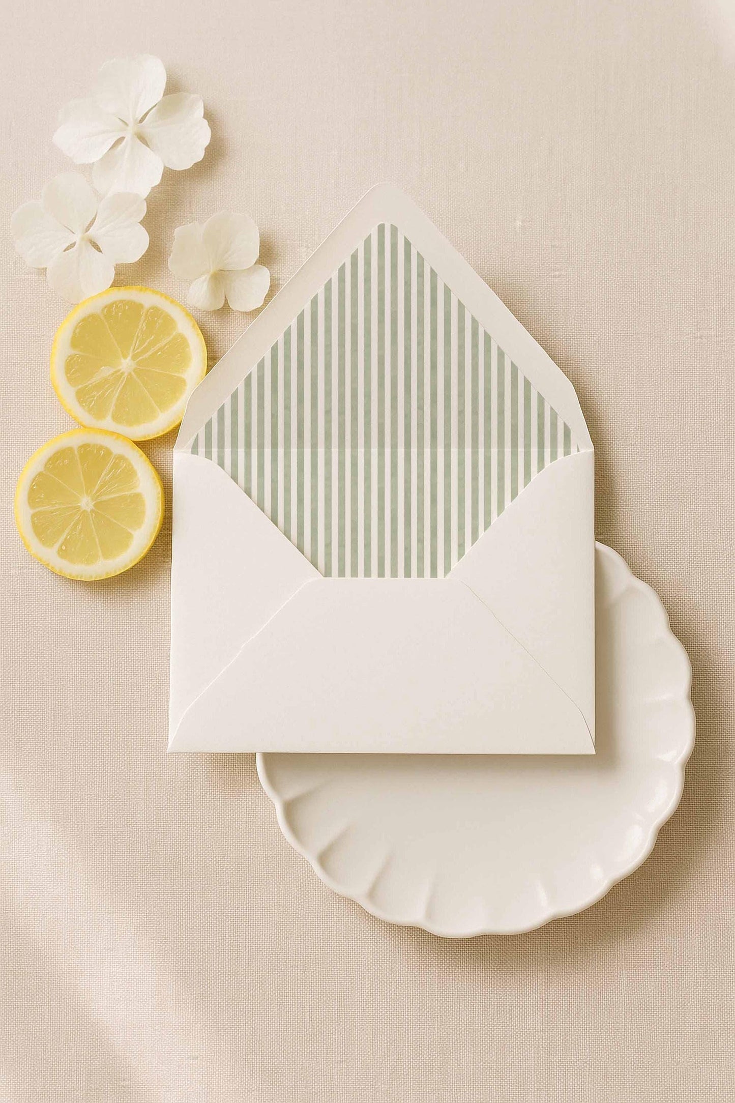 A7 white envelope with green watercolor stripe liner surrounded by soft florals and citrus styling.