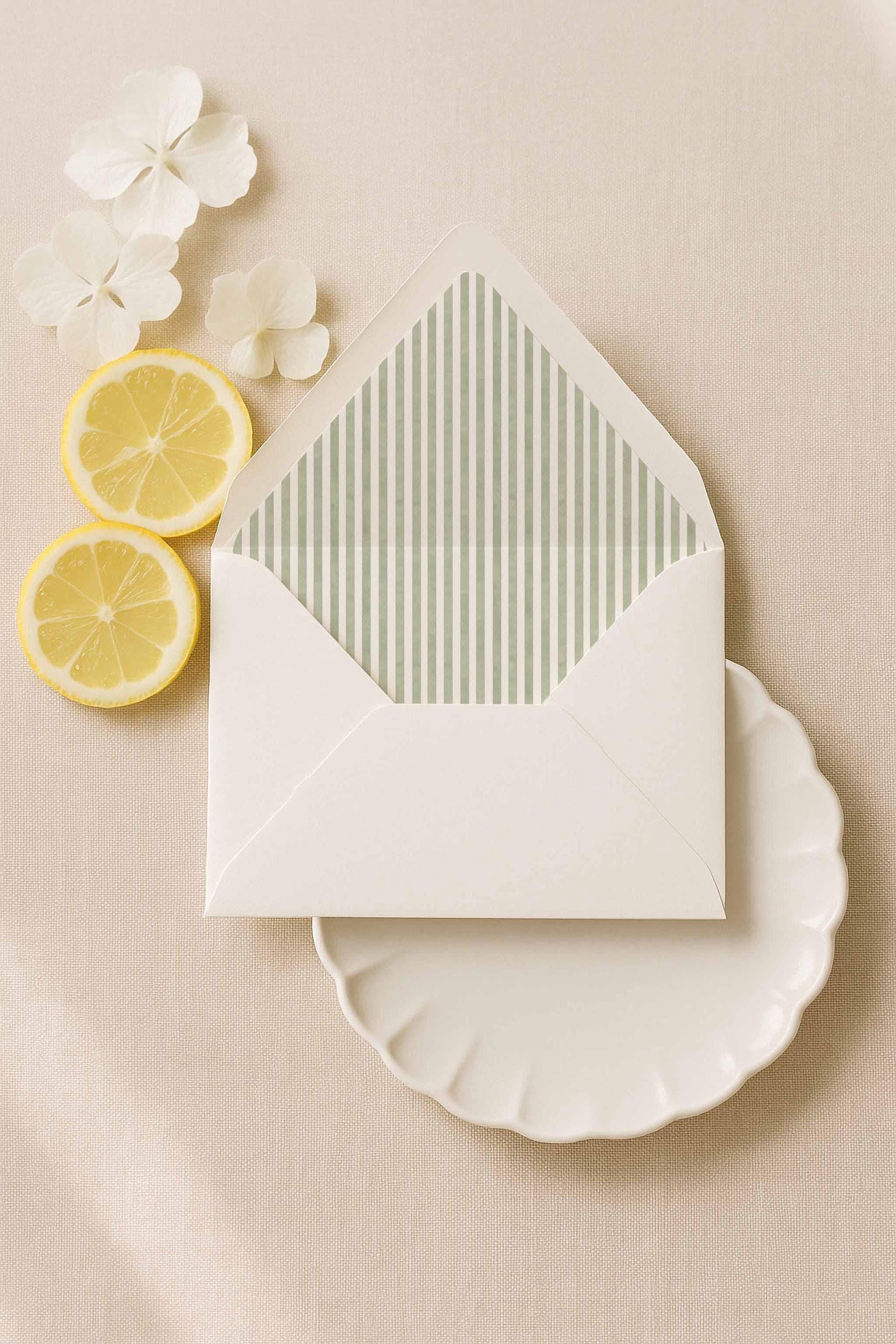 A7 white envelope with green watercolor stripe liner surrounded by soft florals and citrus styling.