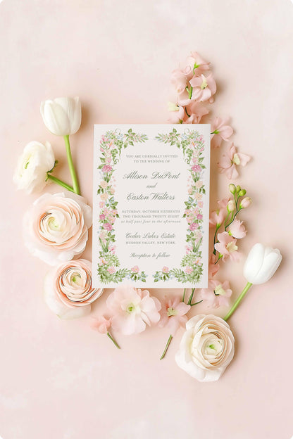 Pink and green watercolor floral wedding invitation suite arranged in a flat lay with blooms and soft pastel accents.”