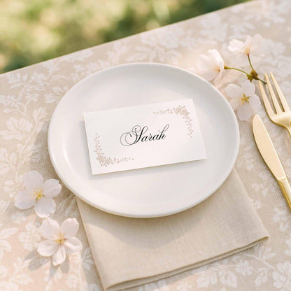 Neutral wedding place card with hand-drawn floral line art on a minimalist table setting.