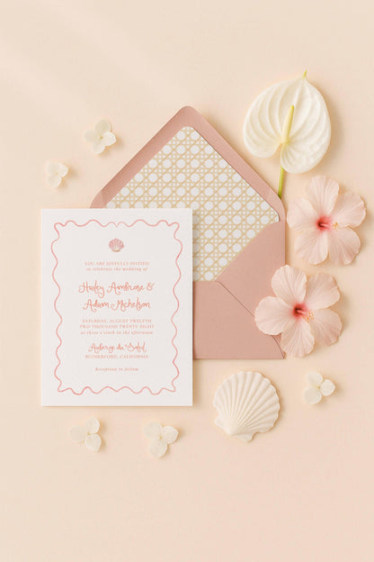 a wedding invitation card with a pink and white color scheme, surrounded by various floral elements such as a white hibiscus flower, a pink hibiscus flower, and a seashell.