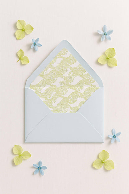 a light blue envelope with a yellow and white patterned design, surrounded by small blue and yellow flowers on a light pink background.