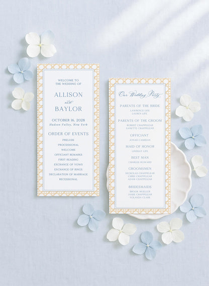 two identical wedding invitation cards with a white background and gold border, placed on a light blue background with scattered white and blue flowers.