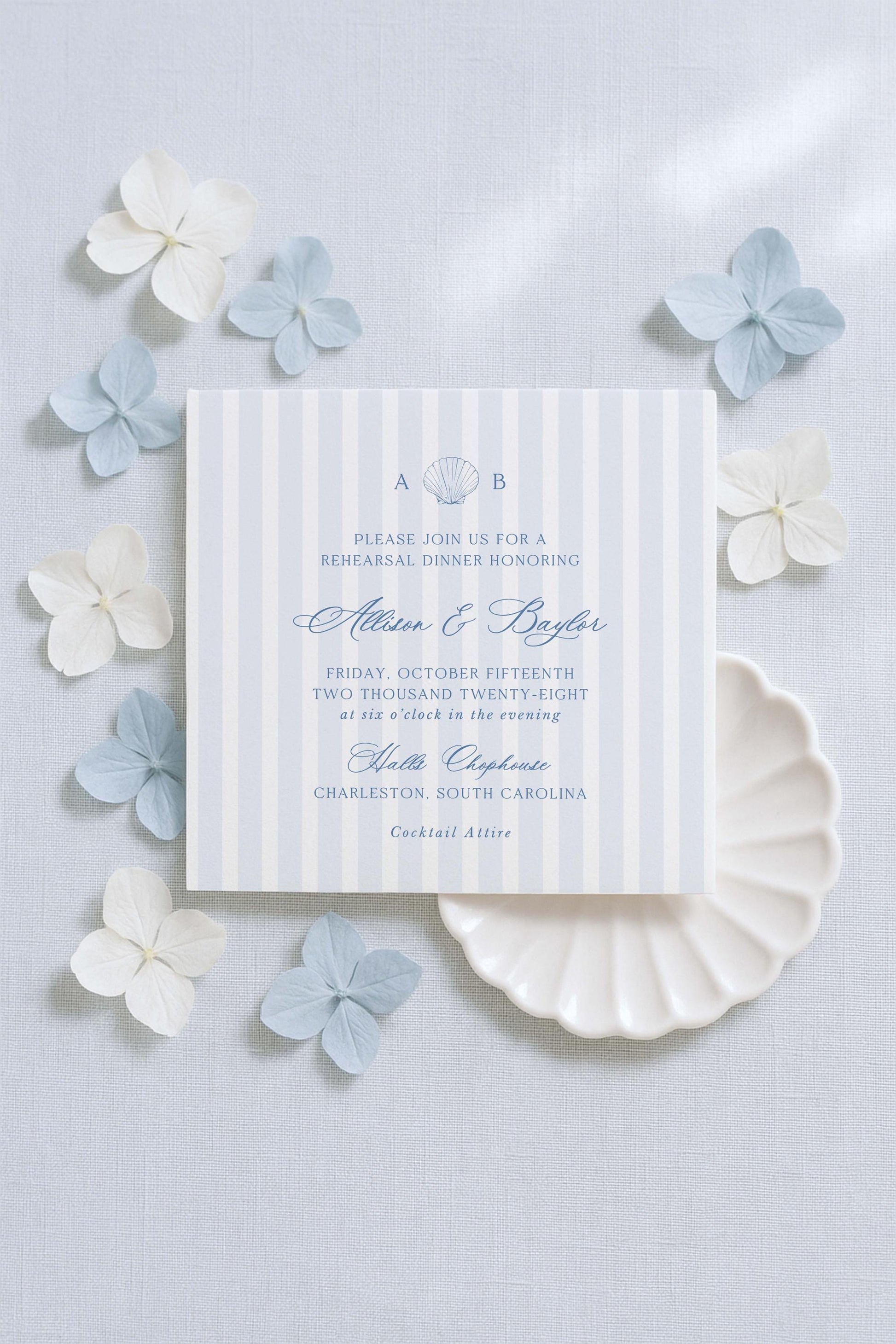 a wedding invitation card with a striped background and a floral design, surrounded by small white and light blue flowers.