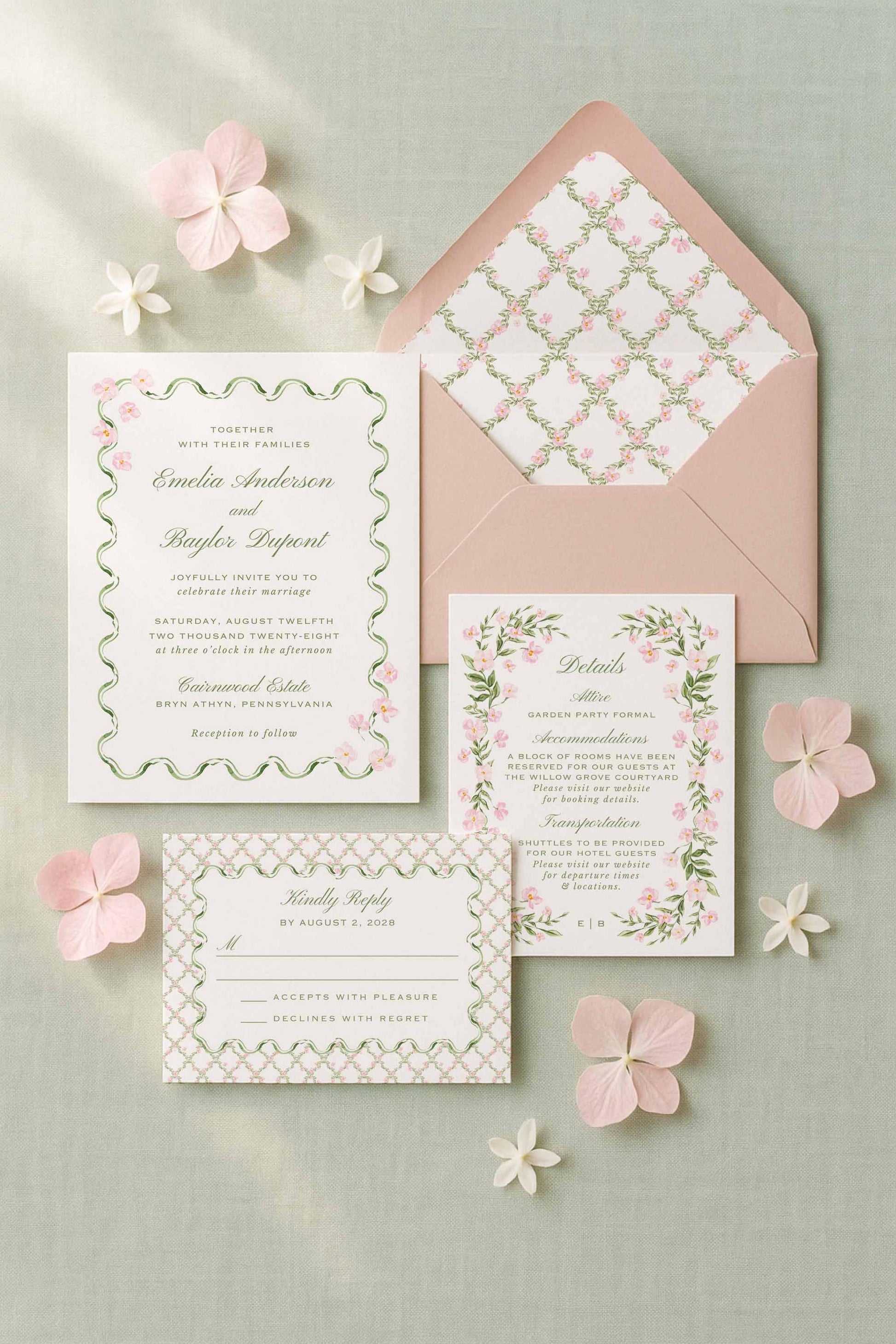 a wedding invitation set against a light green background, with pink flowers scattered around it.