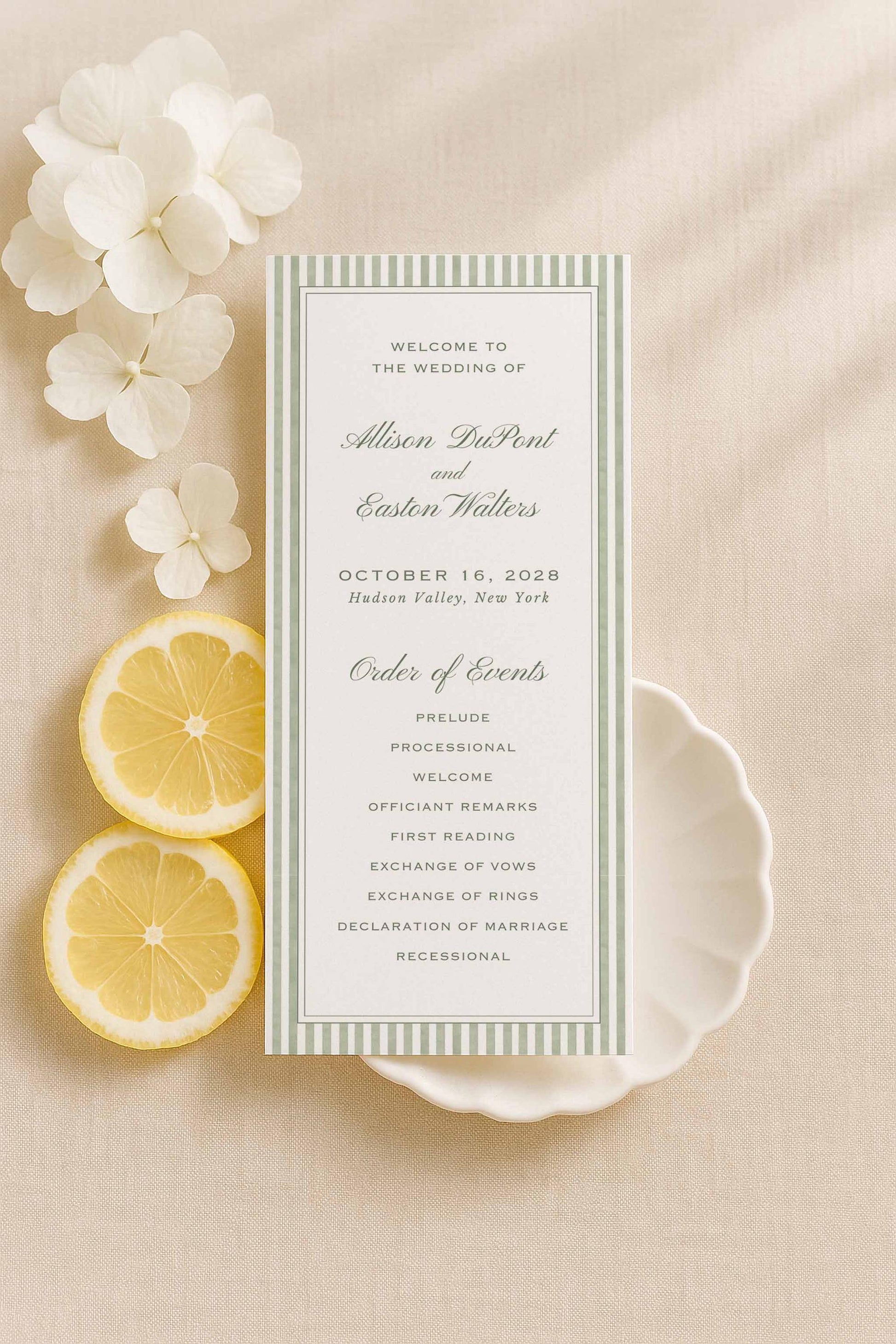 “Tall green striped watercolor wedding program displayed with lemons and neutral florals.”