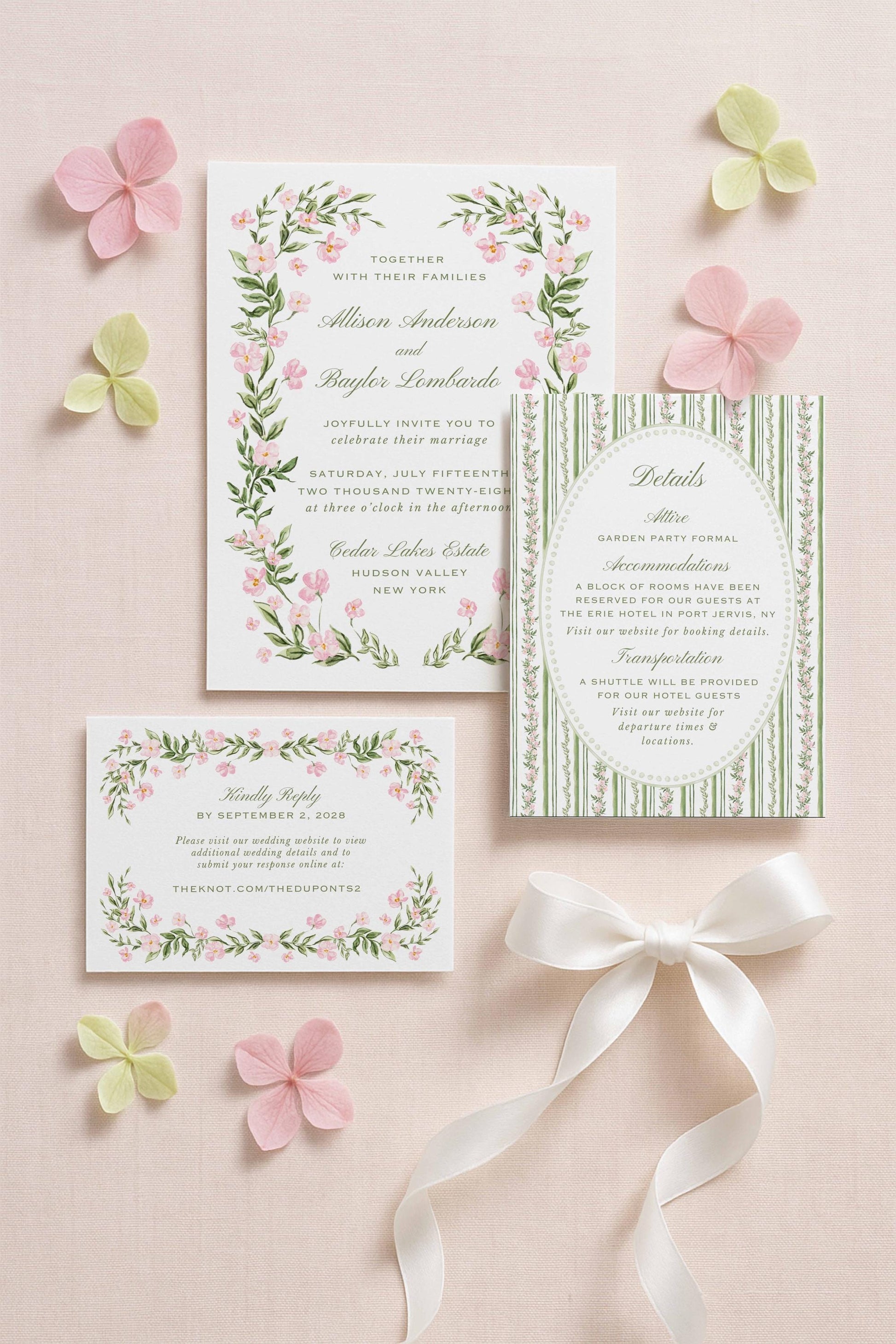 a wedding invitation with a floral design, surrounded by pink and green flowers, and a small card with a white ribbon.