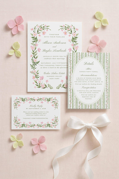 a wedding invitation with a floral design, surrounded by pink and green flowers, and a small card with a white ribbon.