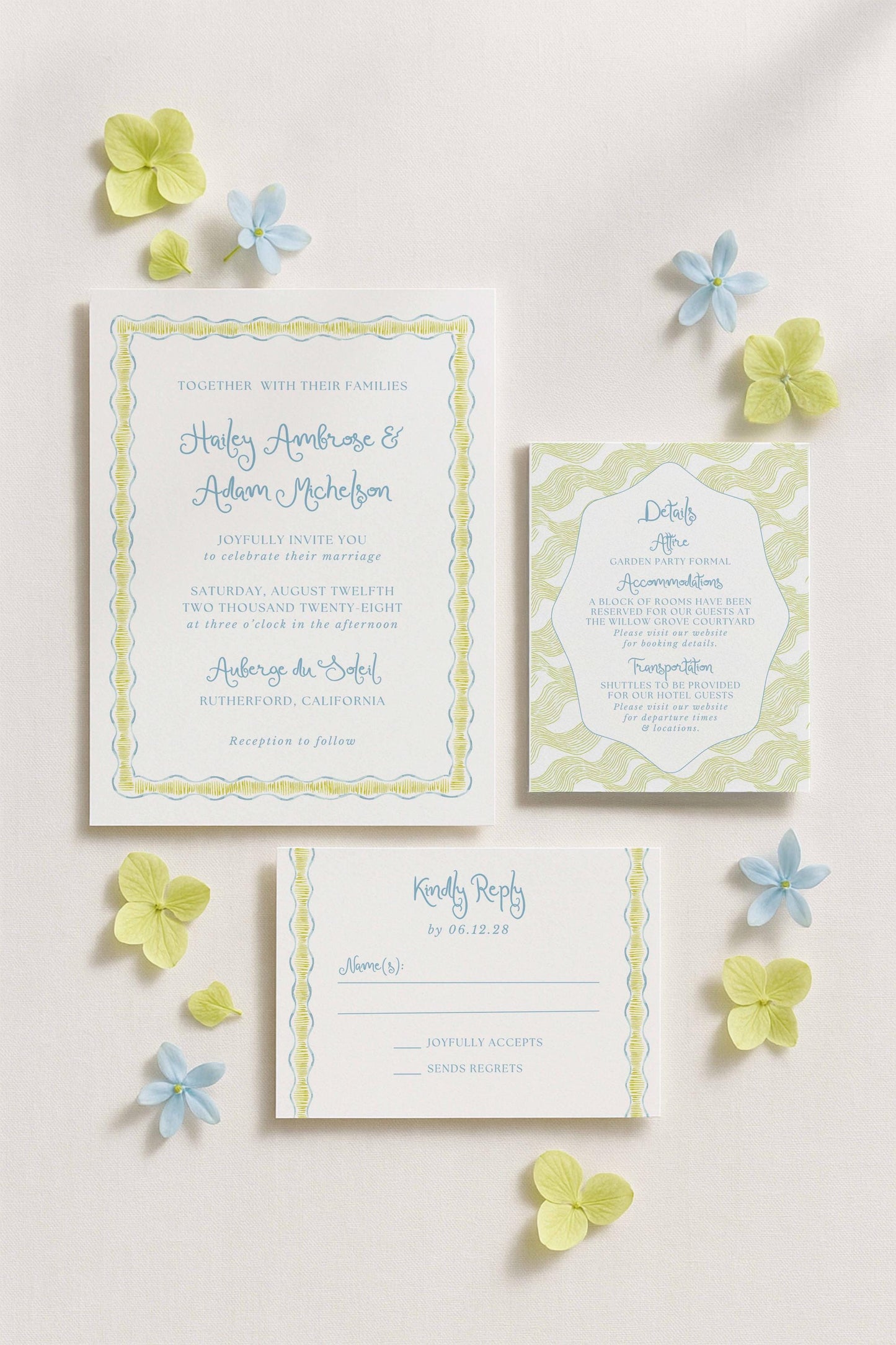a wedding invitation, a response card, and some blue and yellow flowers arranged on a white background.