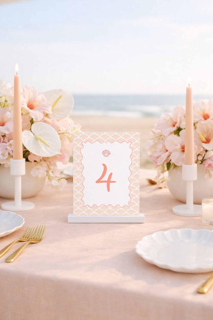 a table set for a romantic dinner, with a tablecloth, candles, flowers, and place settings.