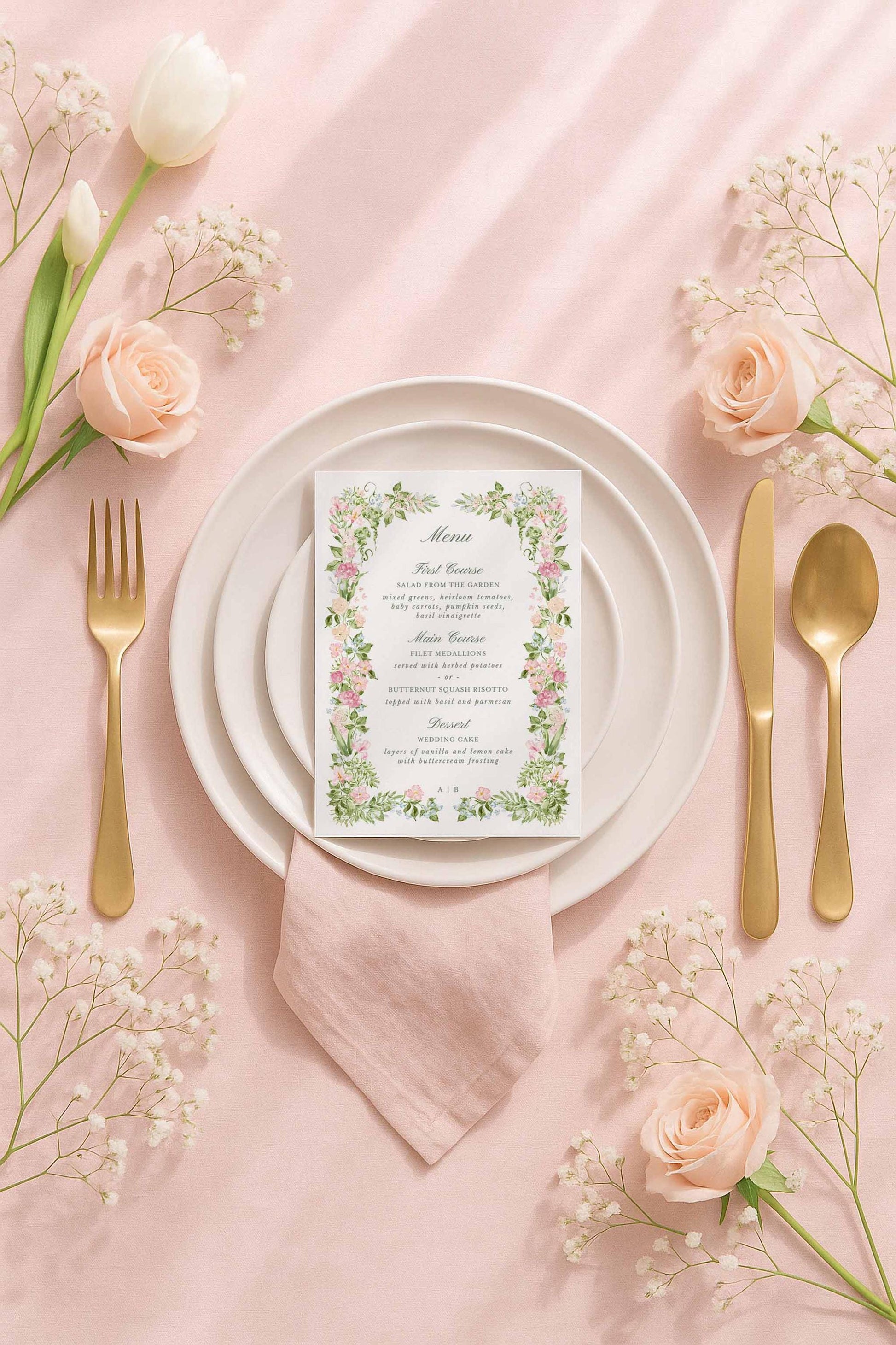 Flat lay of a hand-painted watercolor wedding menu card surrounded by soft pink florals, showcasing an elegant green floral border and customizable Canva text.
