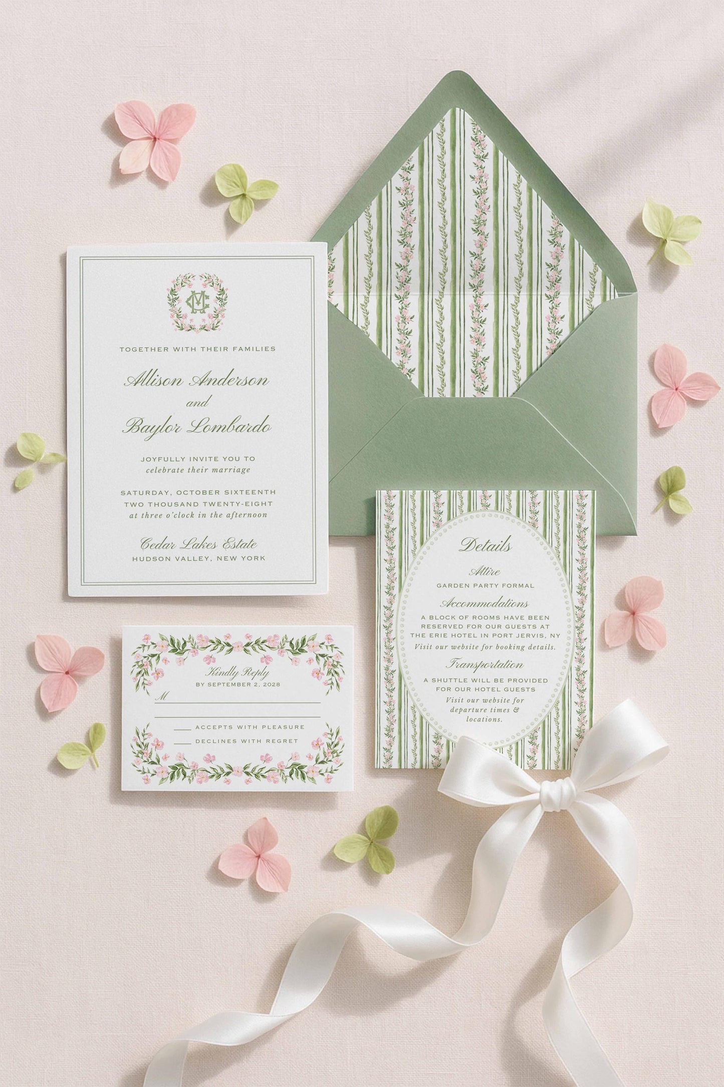 a wedding invitation set against a light pink background, featuring a green envelope, a white card, and a small card with a floral design.