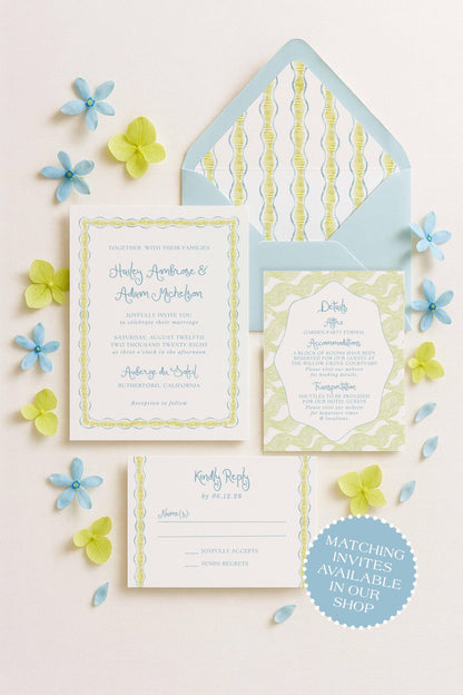 a wedding invitation, an envelope, and a response card, all arranged on a light background with blue and yellow flowers scattered around.