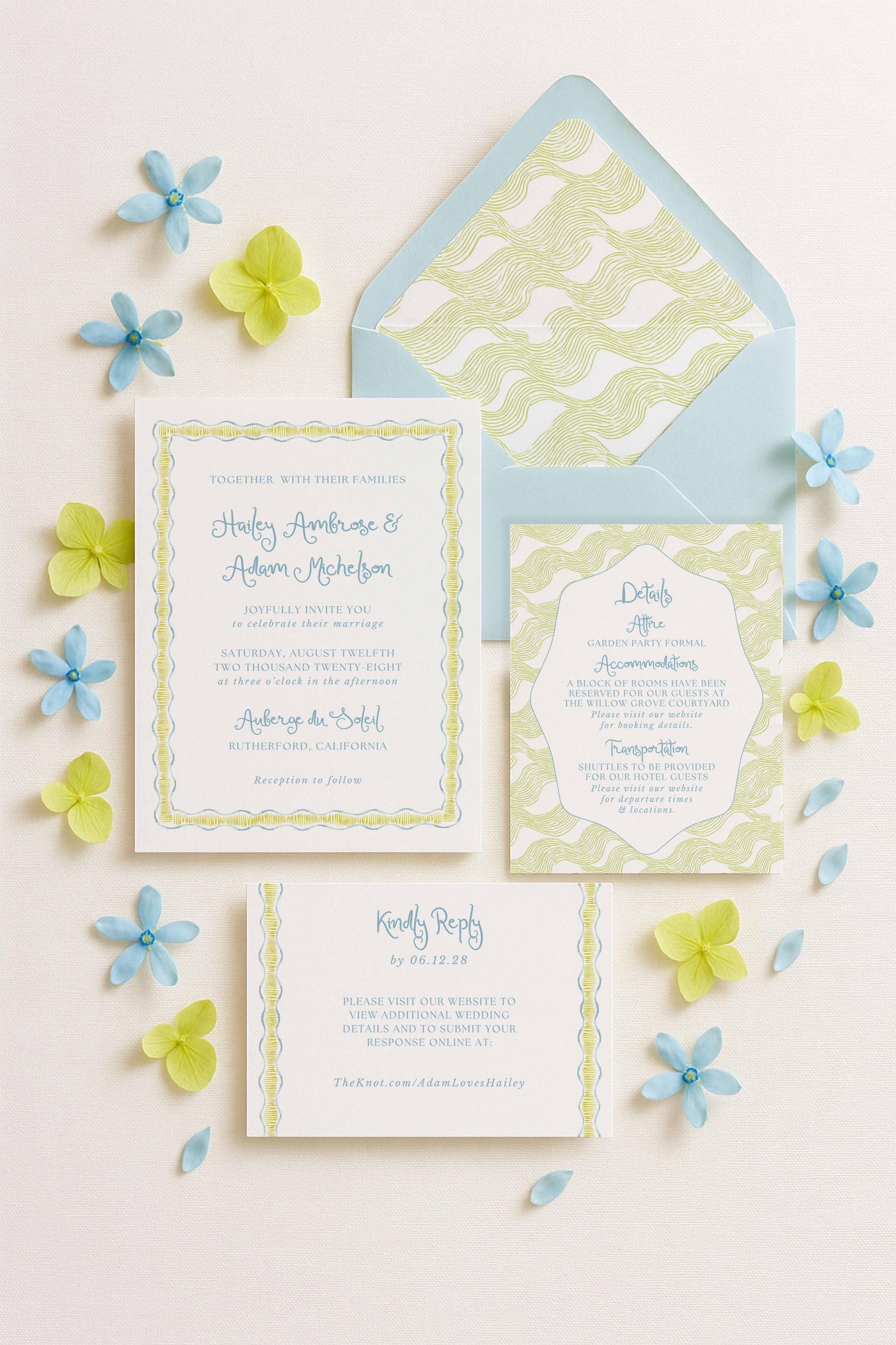 a wedding invitation, an envelope, and some blue and yellow flowers arranged on a white background.