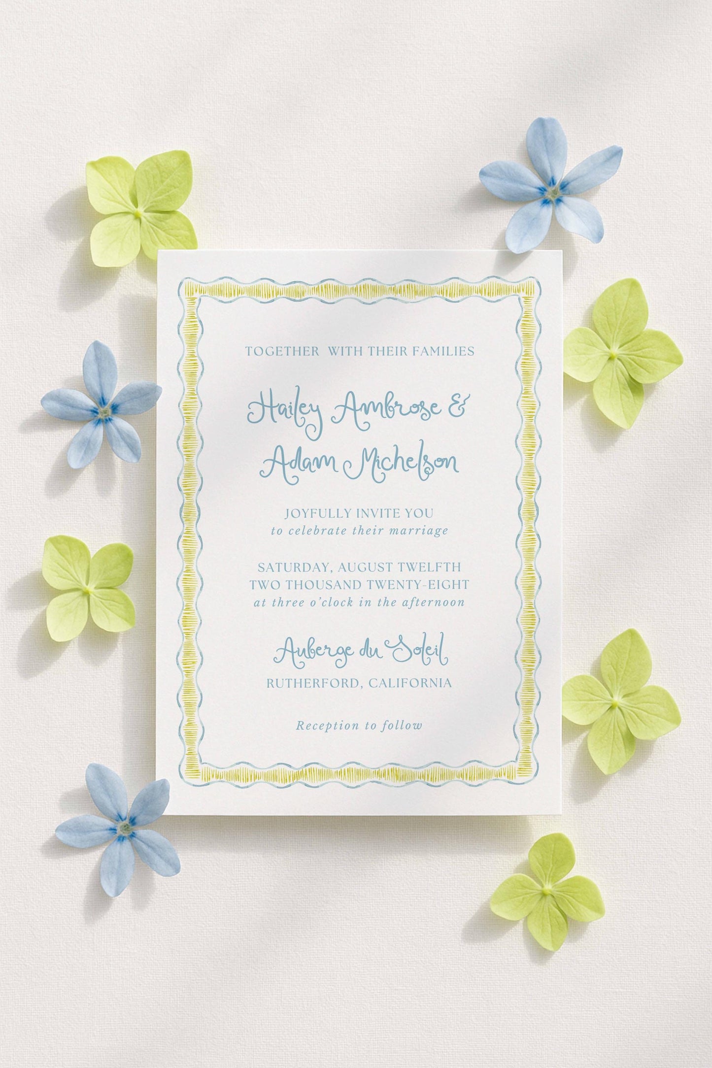 a wedding invitation card with a yellow border and blue flowers surrounding it.