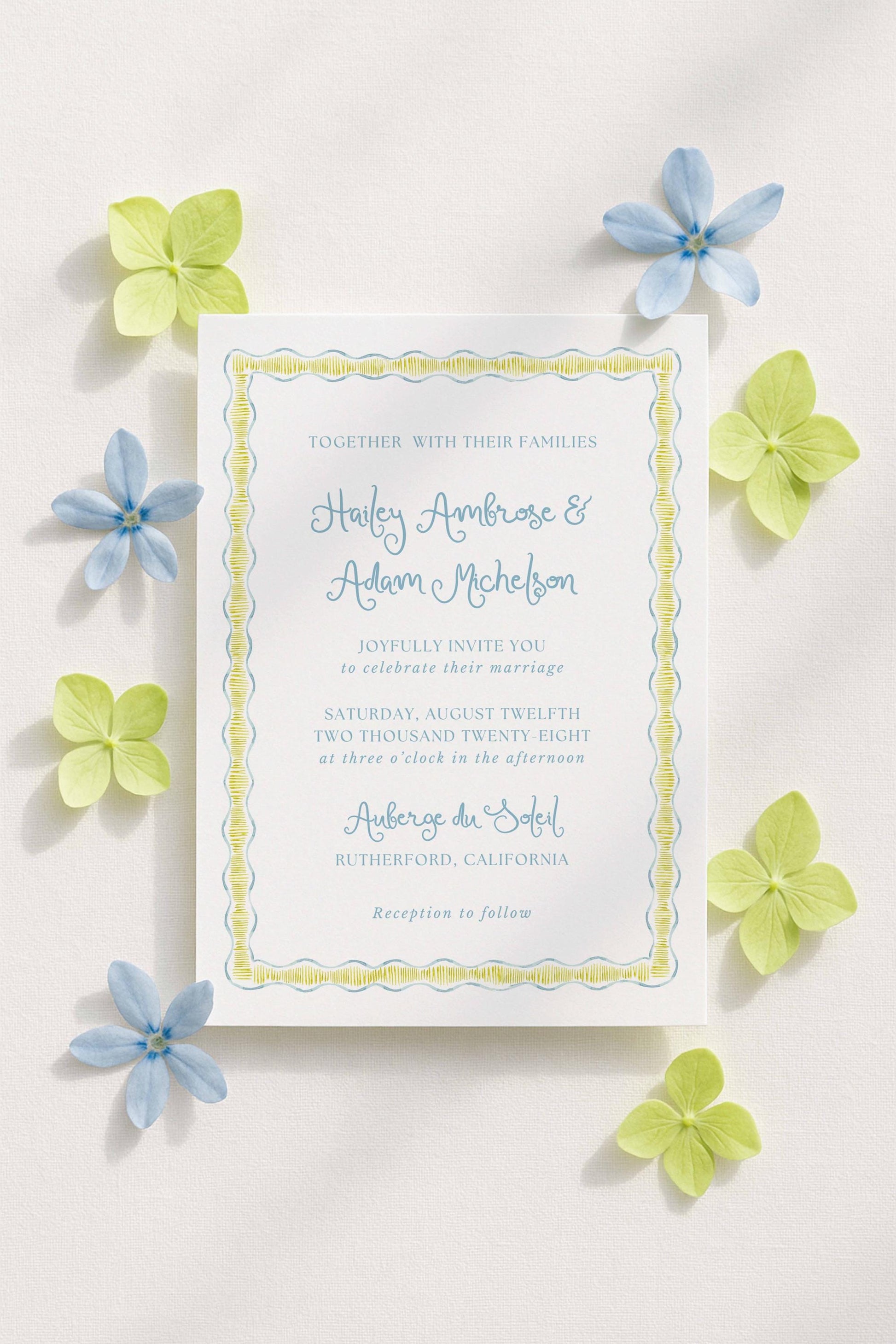 a wedding invitation card with a yellow border and blue flowers surrounding it.