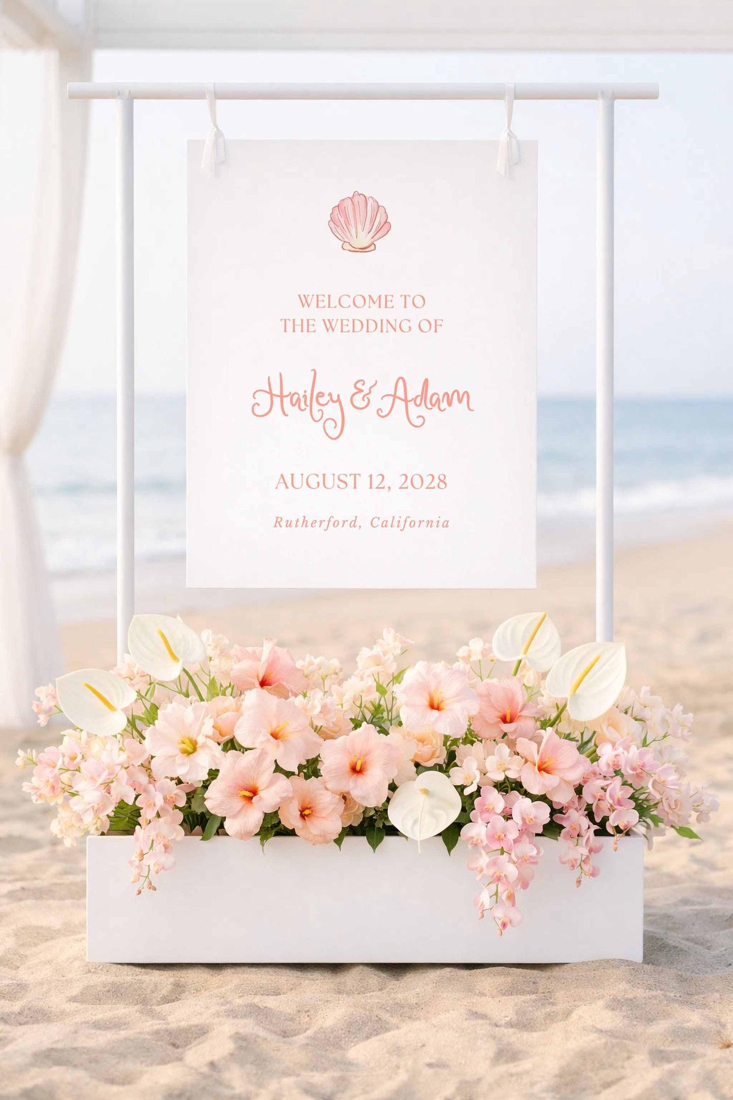 a wedding invitation sign with a beach scene in the background, displaying the names "Haley & Adam" and the date "AUGUST 12, 2028" in a coastal town.