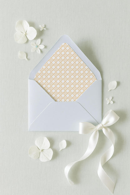 a white envelope with a bow, surrounded by white flowers and petals on a light background.