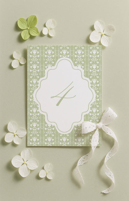 a green and white floral design with a white ribbon and a small white flower, all set against a light green background.