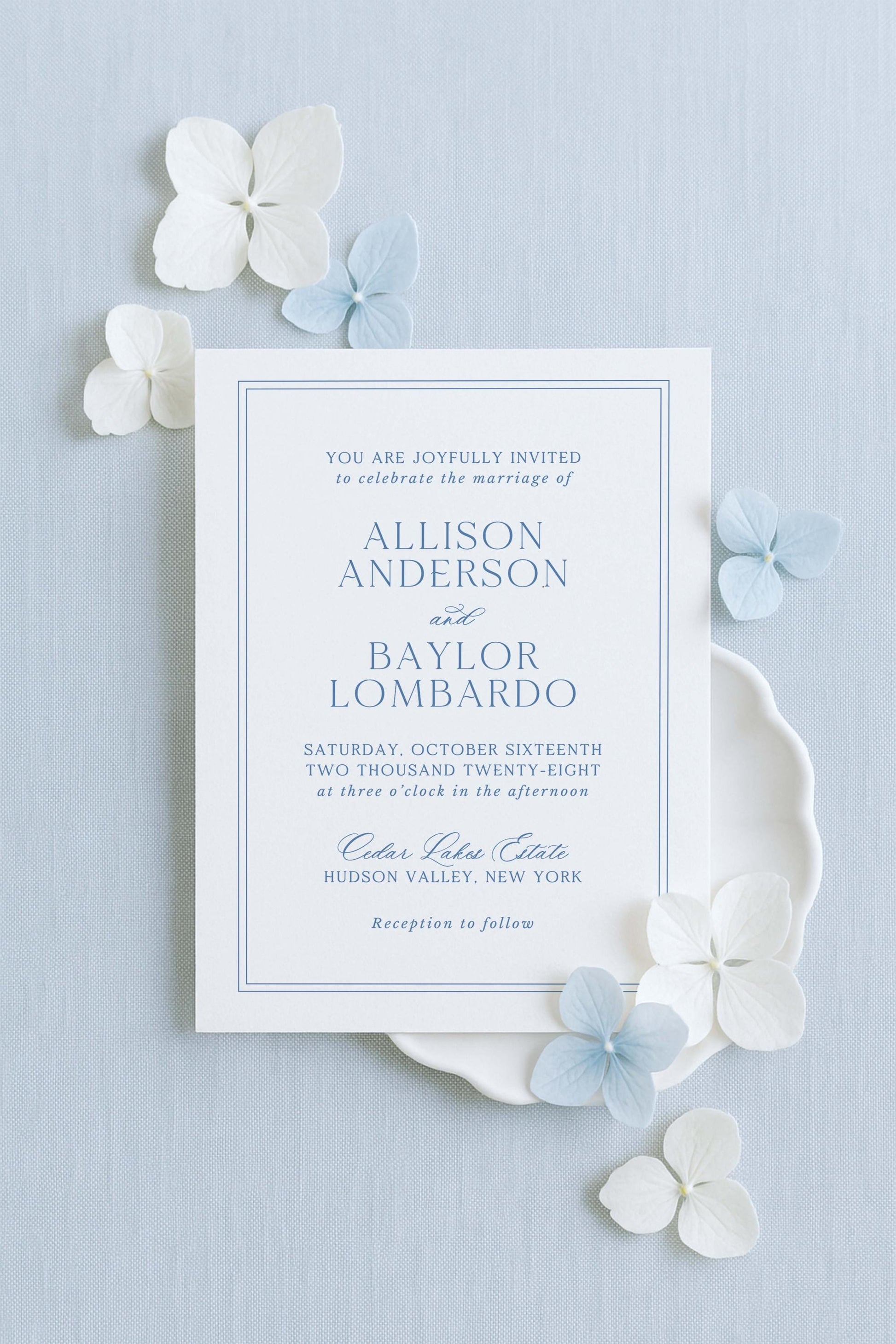 The image is a wedding invitation card for the marriage of Allison Anderson and Bayl Lombardo. The card is set against a light blue background and features white text and blue floral accents.