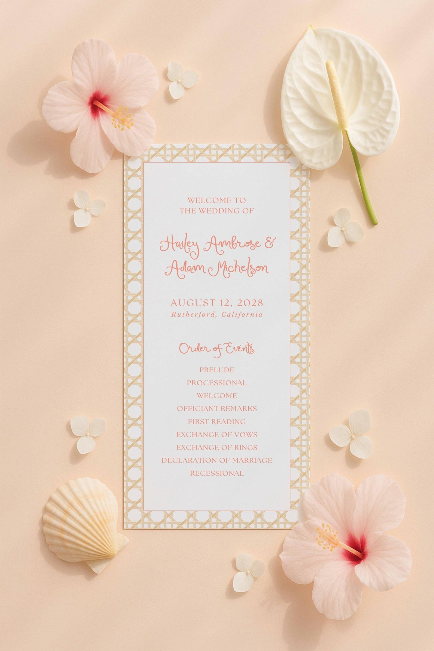 a wedding invitation card with a floral design, surrounded by various flowers and seashells.