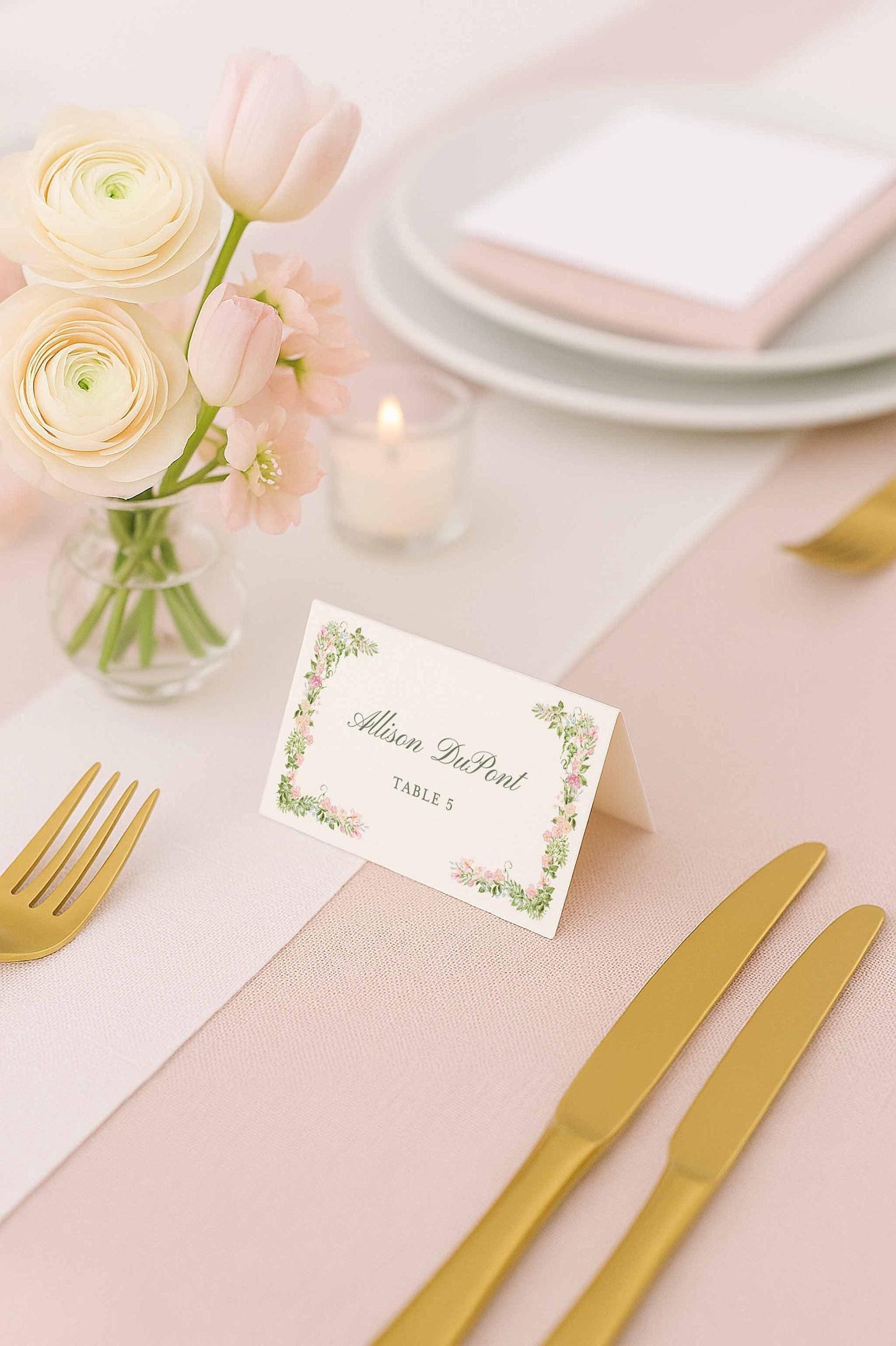 Editable floral place card displayed beside delicate wedding florals and soft candlelight.