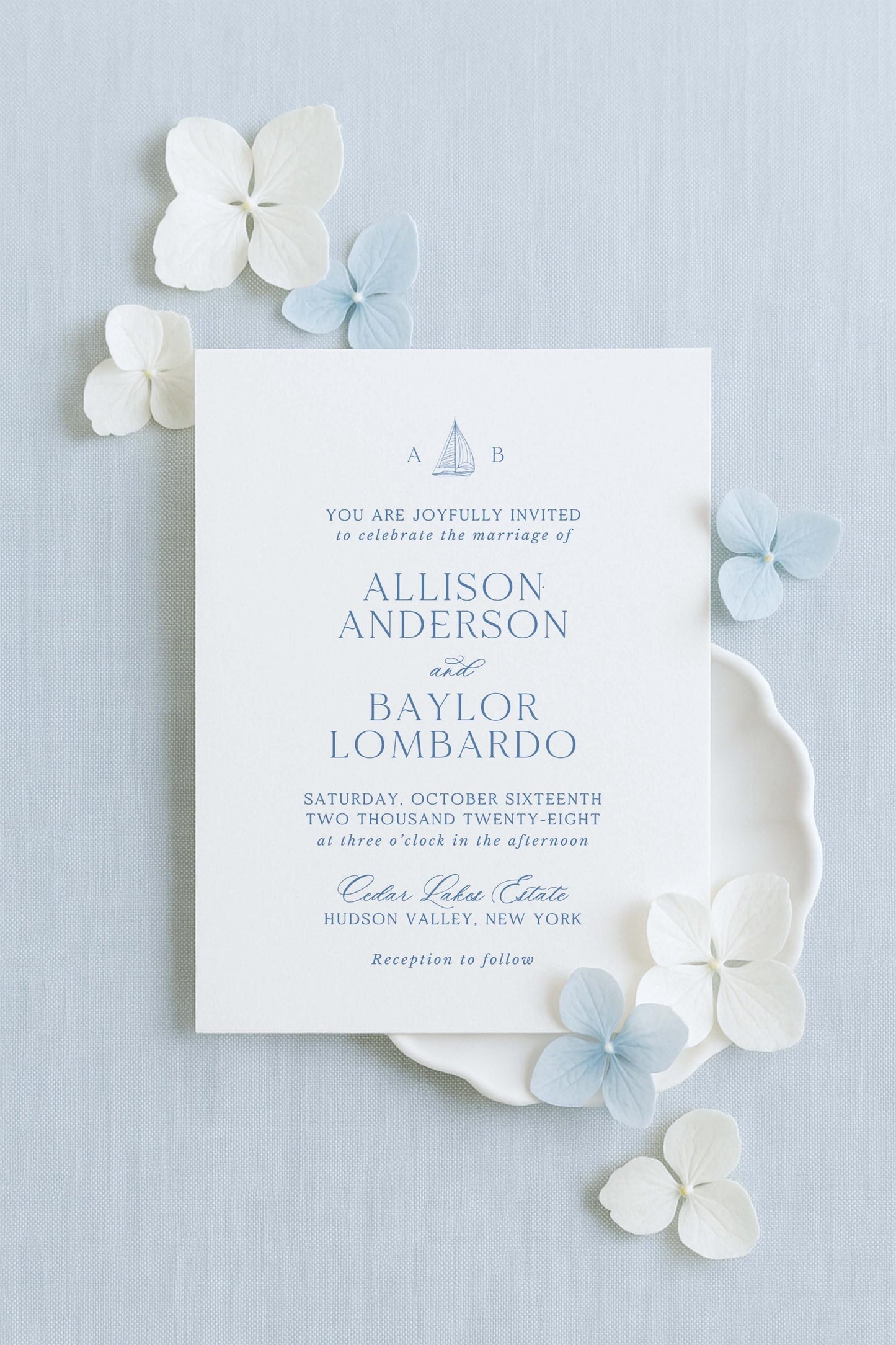 The image is a wedding invitation card with a light blue background, white text, and decorative elements such as white and light blue flowers.