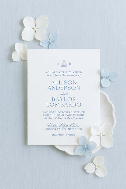 The image is a wedding invitation card with a light blue background, white text, and decorative elements such as white and light blue flowers.