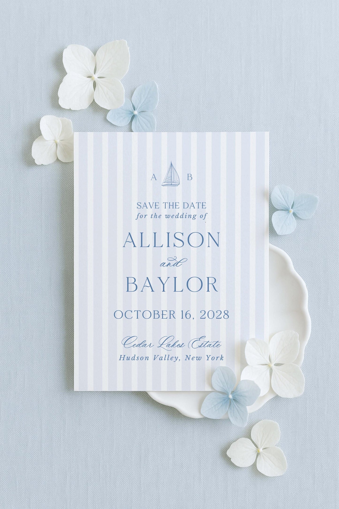 a wedding invitation card with a striped background and decorative elements such as white and blue flowers.