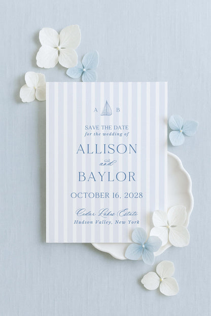 a wedding invitation card with a striped background and decorative elements such as white and blue flowers.