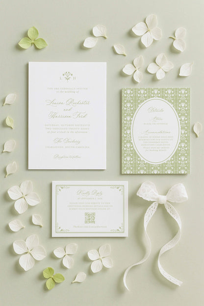 a wedding invitation, a small card, and some white flowers arranged on a light background.
