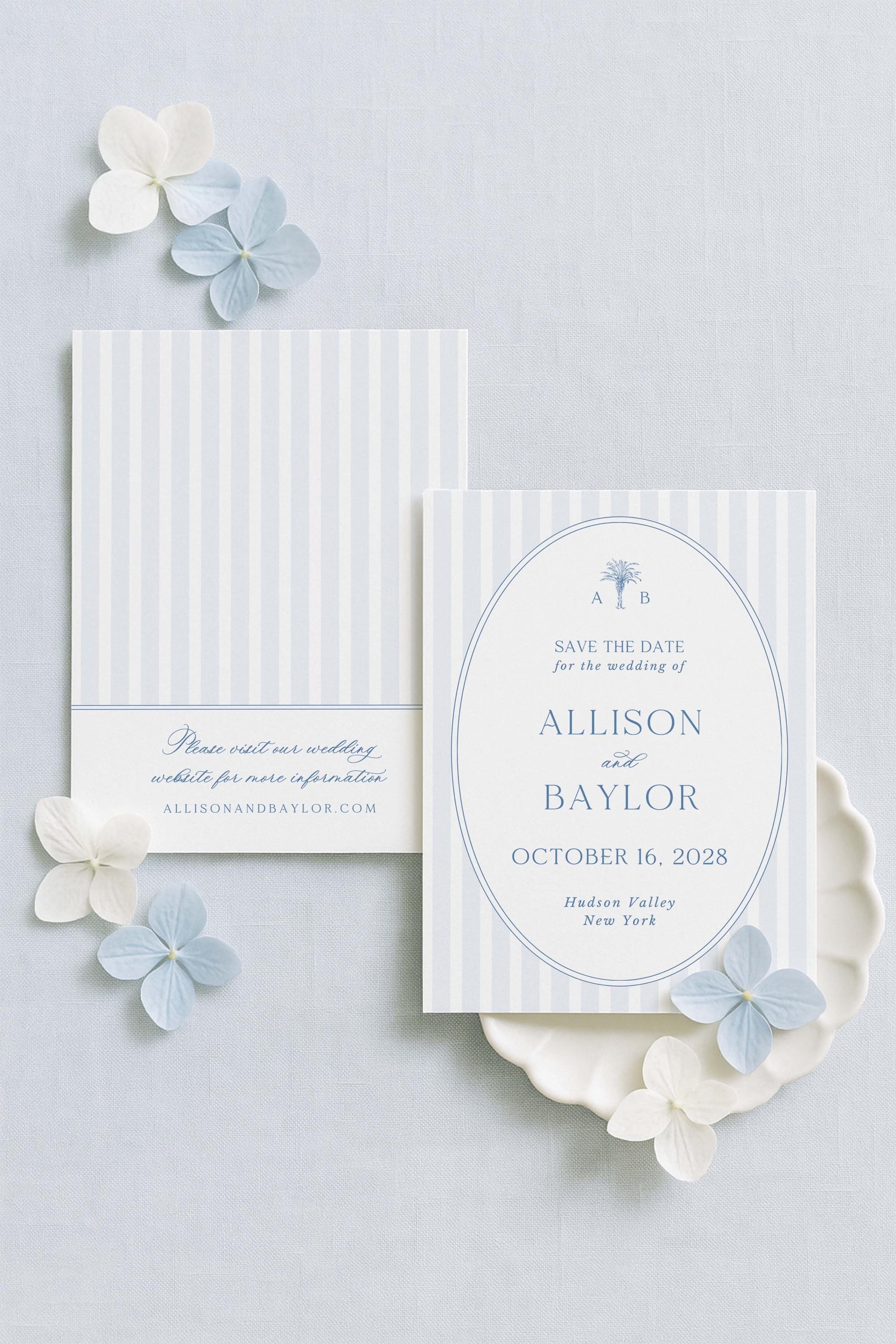 a wedding invitation card with a white background and blue and white striped design. The card is adorned with small white flowers and has text that reads "Save the date for the wedding of Allison and Bayl" and "October 16, 2028 Hudson Valley New York".