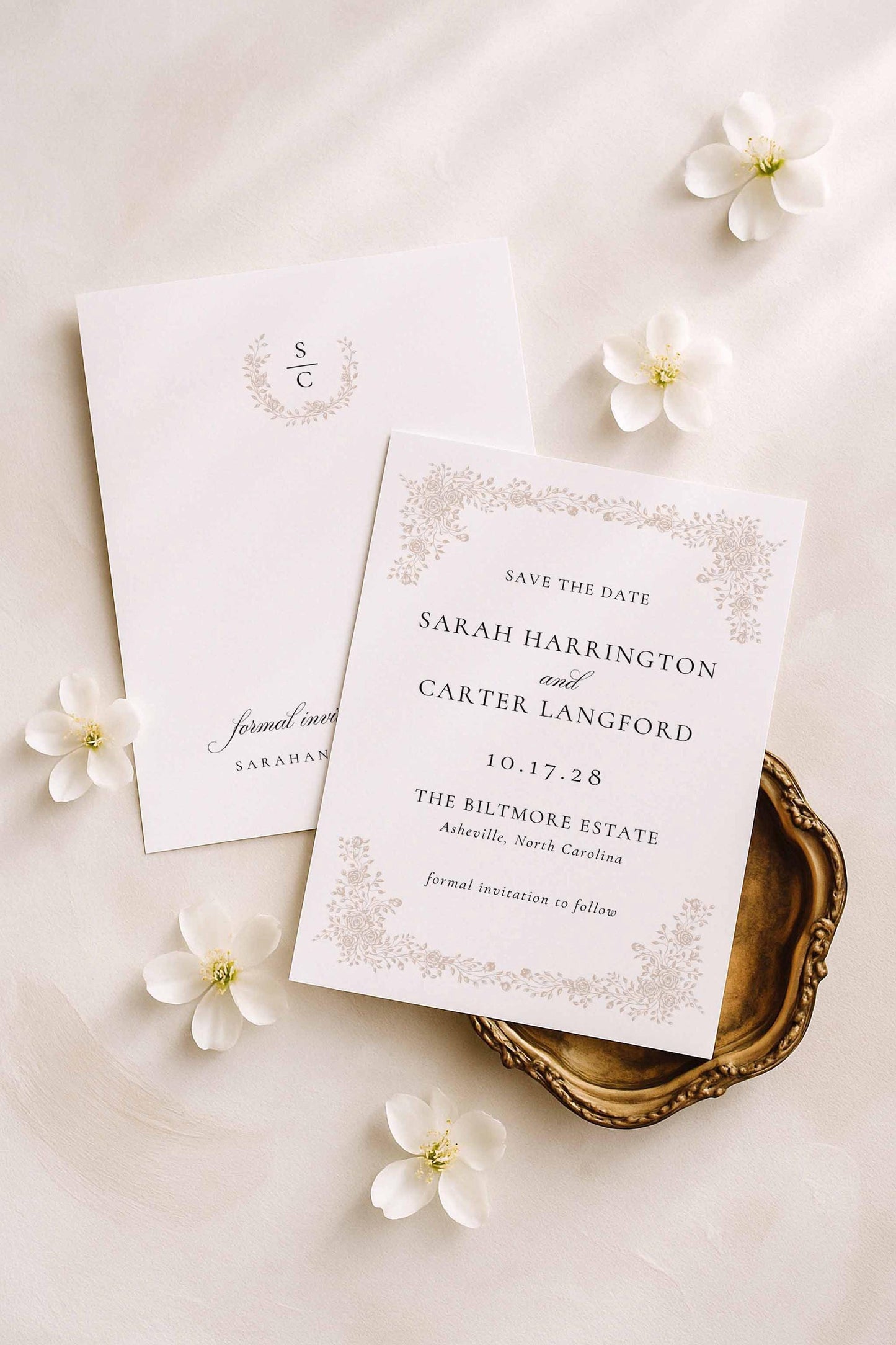 Minimalist botanical save the date displayed with ivory flowers and soft beige styling.