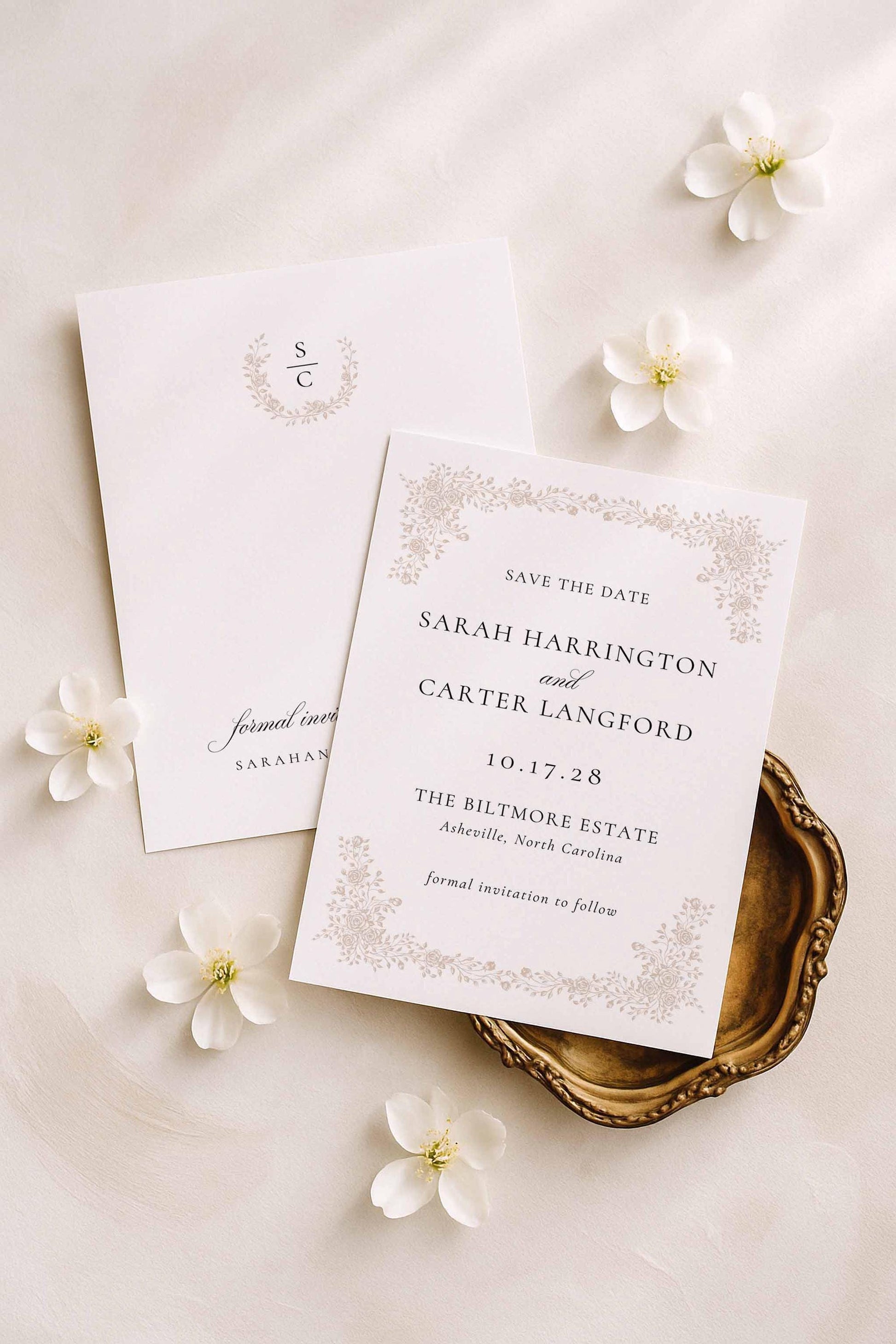 Minimalist botanical save the date displayed with ivory flowers and soft beige styling.