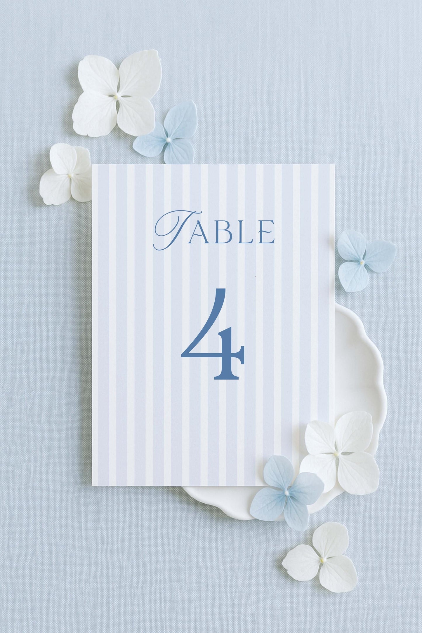 a table number 4 with decorative elements surrounding it, including white flowers and a light blue background.