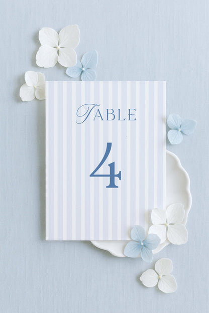 a table number 4 with decorative elements surrounding it, including white flowers and a light blue background.