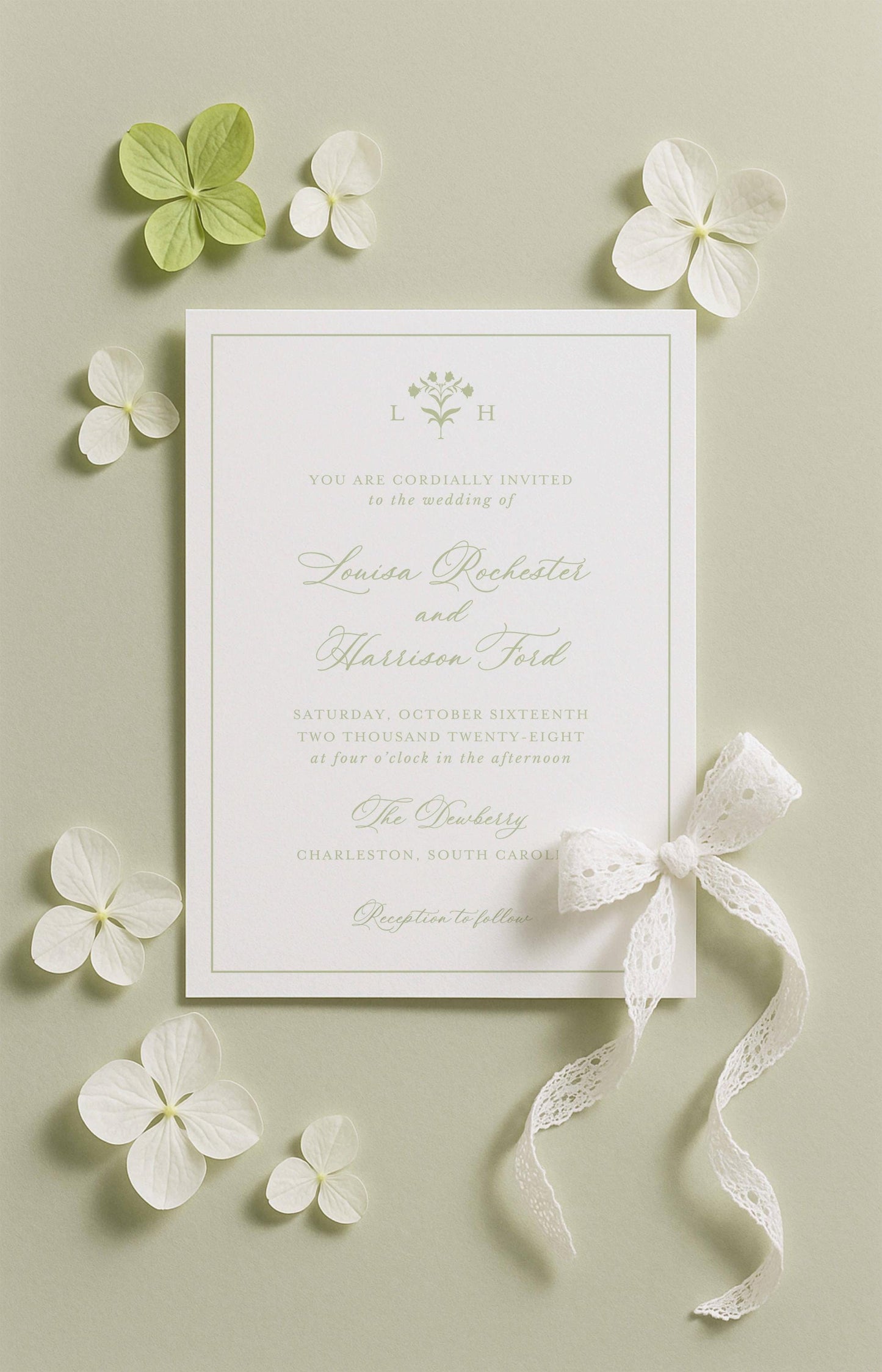 The image is a wedding invitation card with a white background, surrounded by white flowers and a white ribbon.