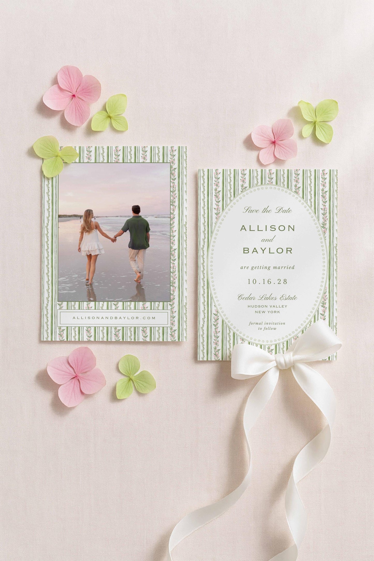 a wedding invitation card with a photo of a couple and a ribbon. The card is placed on a light pink background with pink and green flowers.