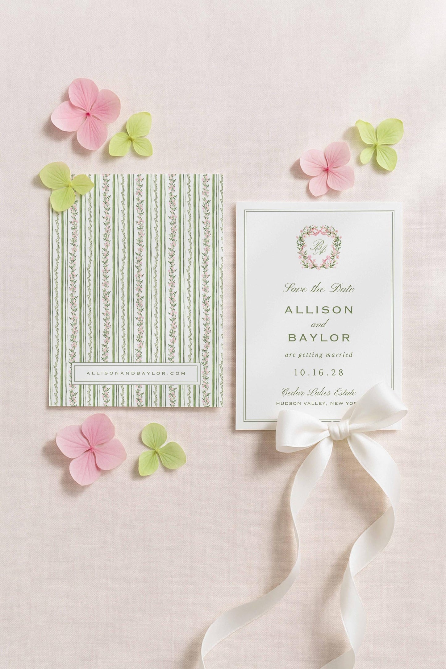 a wedding invitation card with a green and white striped pattern, a white card with a floral design, and pink and green flowers surrounding the cards.