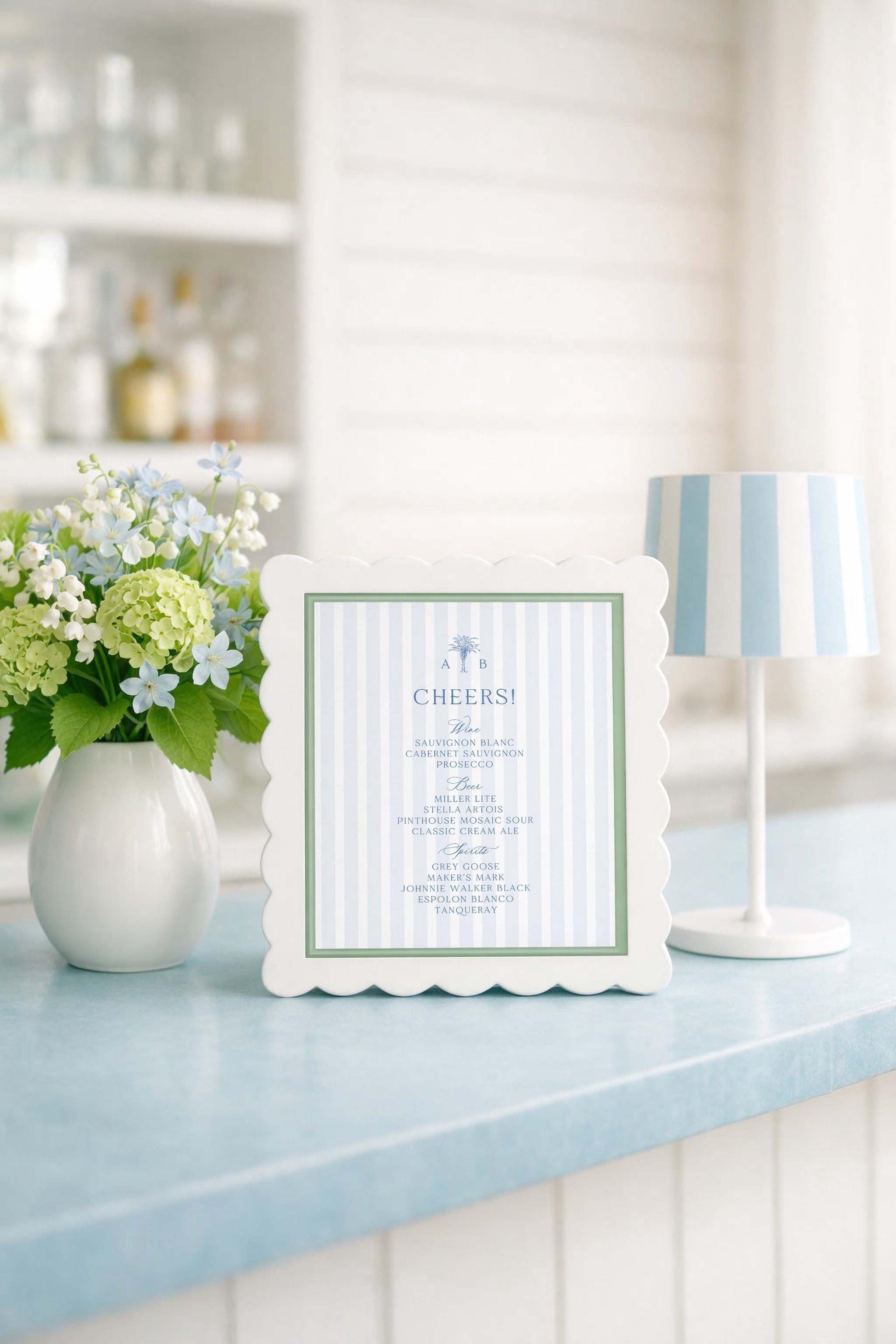 a framed menu with a blue and white striped border, placed on a blue countertop next to a vase of white and green flowers.