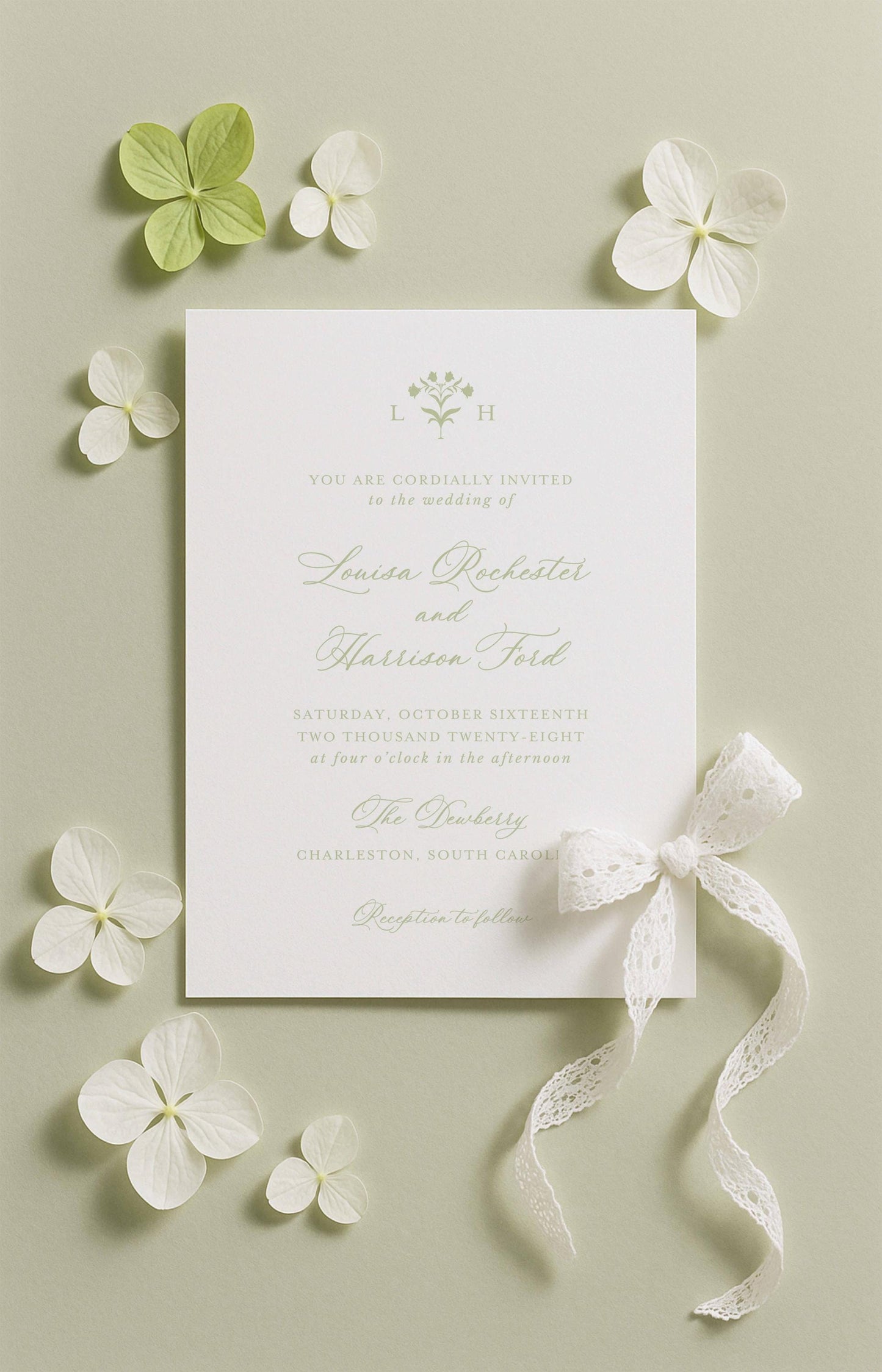 The image is a wedding invitation card with a white background, surrounded by white flowers and a white ribbon.