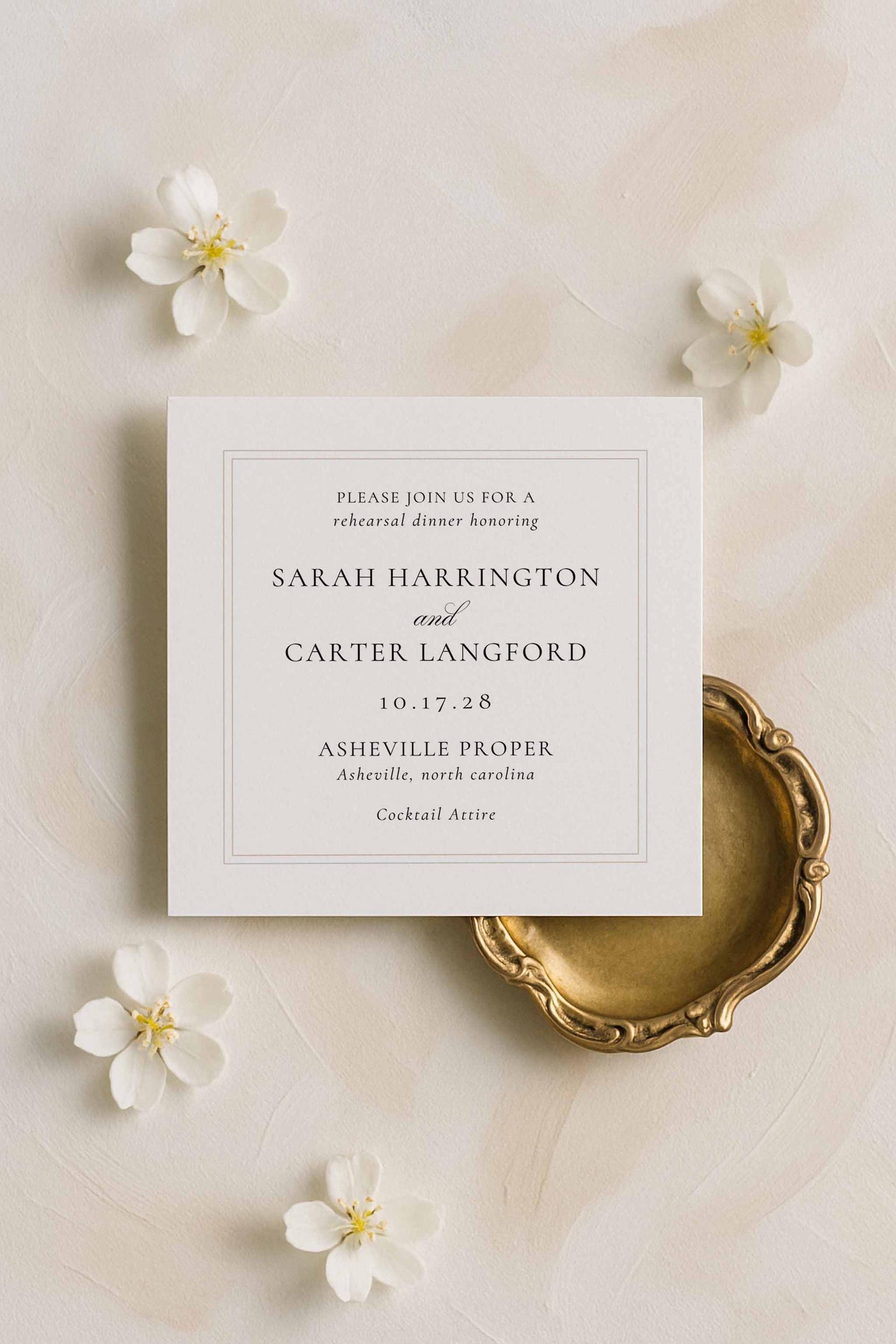Minimalist rehearsal dinner card featuring a border illustration in warm neutrals, styled with classic gold and ivory details.