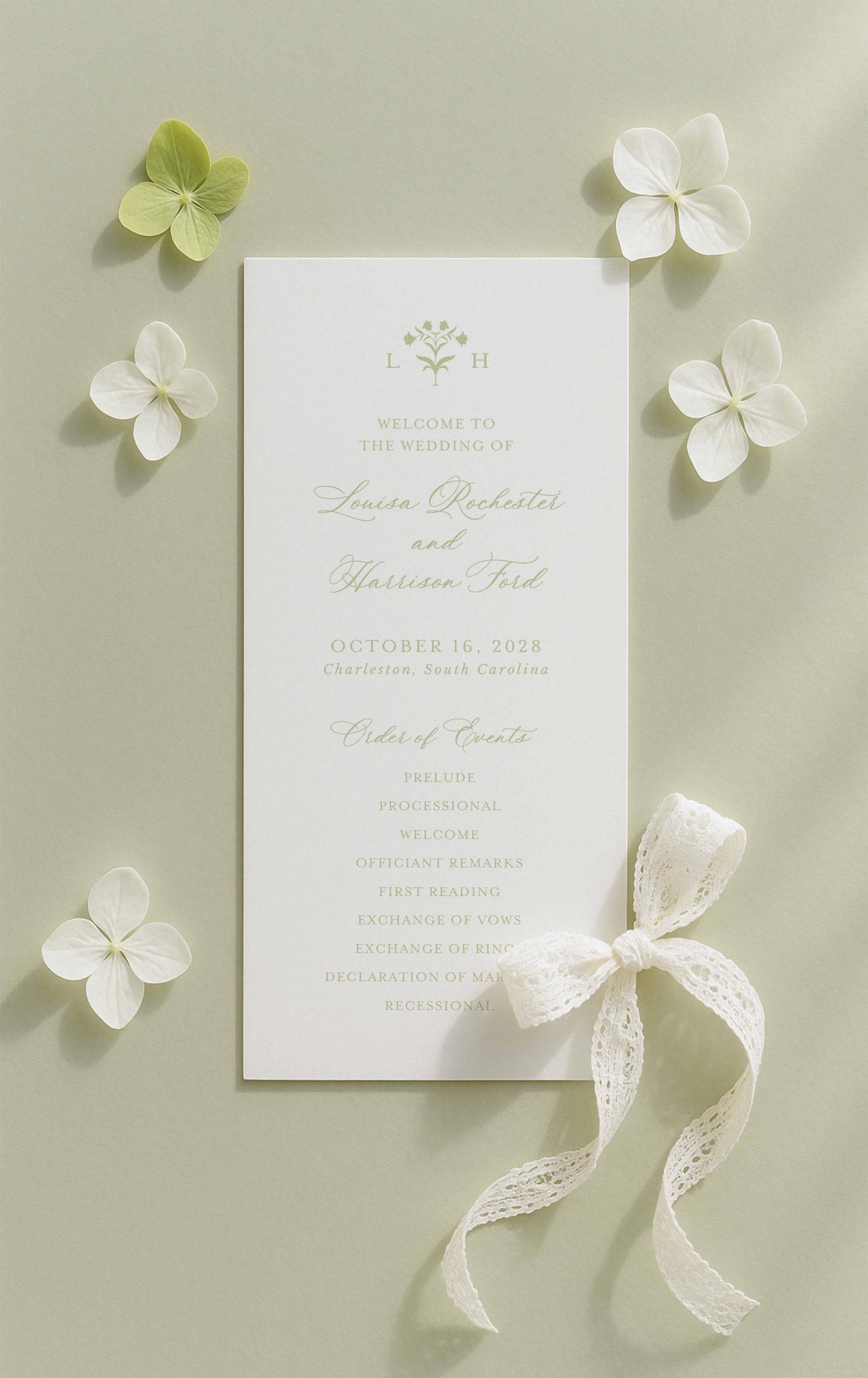 a wedding invitation card with a white background, surrounded by white flowers and a white ribbon.