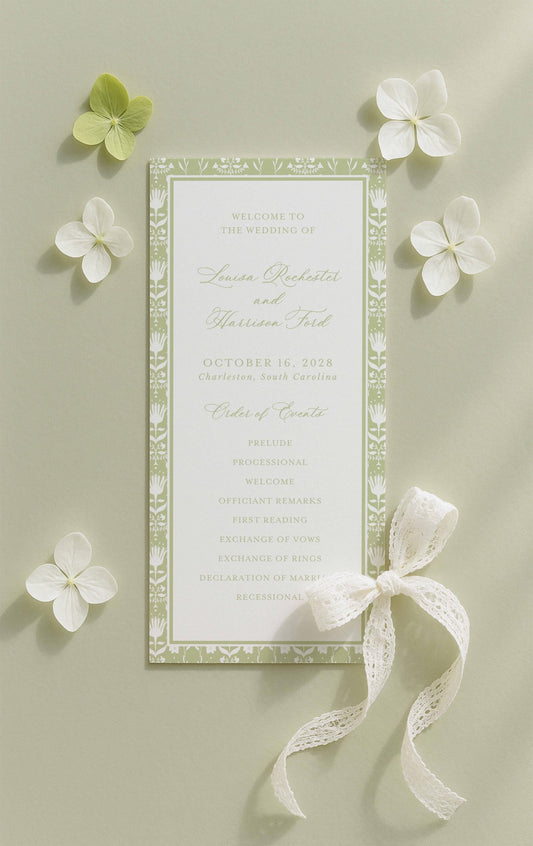 a wedding invitation card with a green and white color scheme, surrounded by white flowers and a white ribbon.