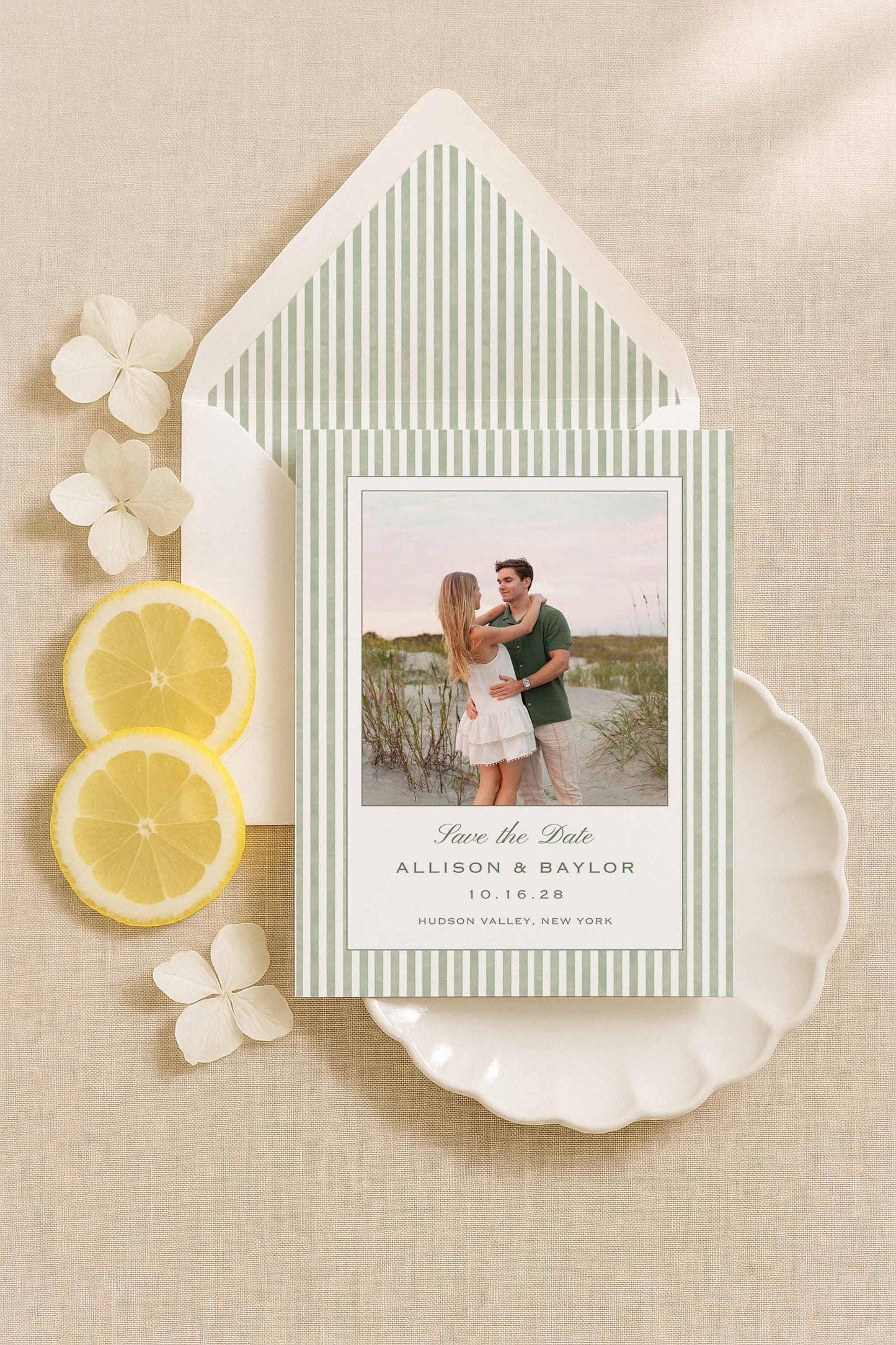 Green striped watercolor Save the Date card and envelope liner with engagement photos, styled with lemons and white flowers.