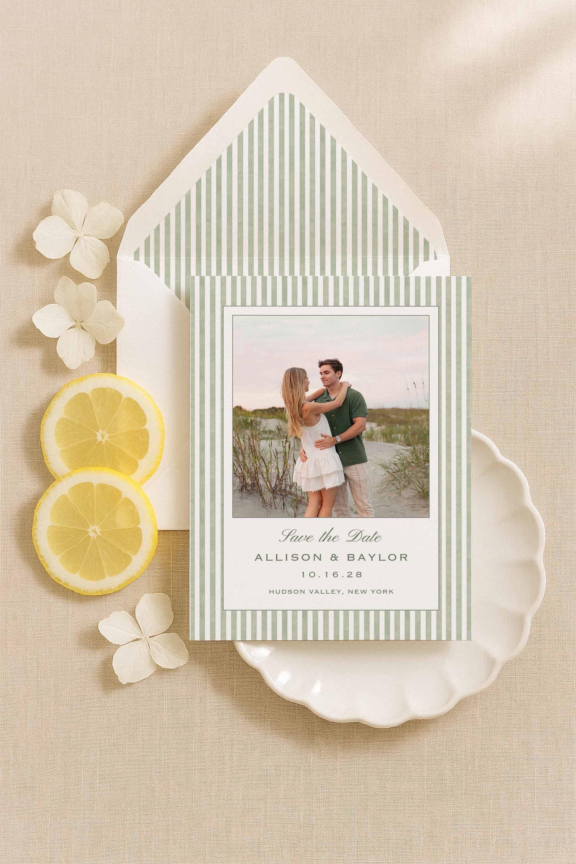 Green striped watercolor Save the Date card and envelope liner with engagement photos, styled with lemons and white flowers.