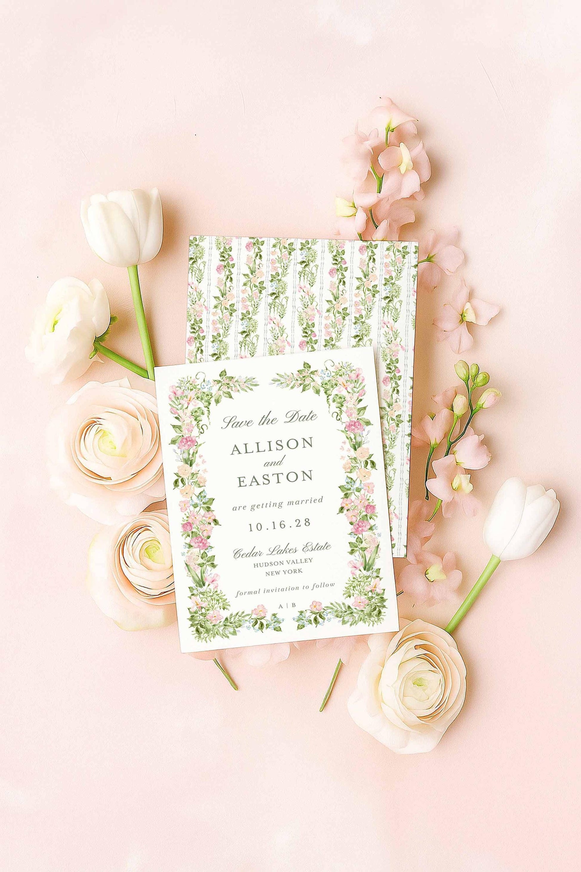 A floral watercolor Save the Date card with matching patterned backer, styled flat-lay on a blush background with ranunculus and tulips.