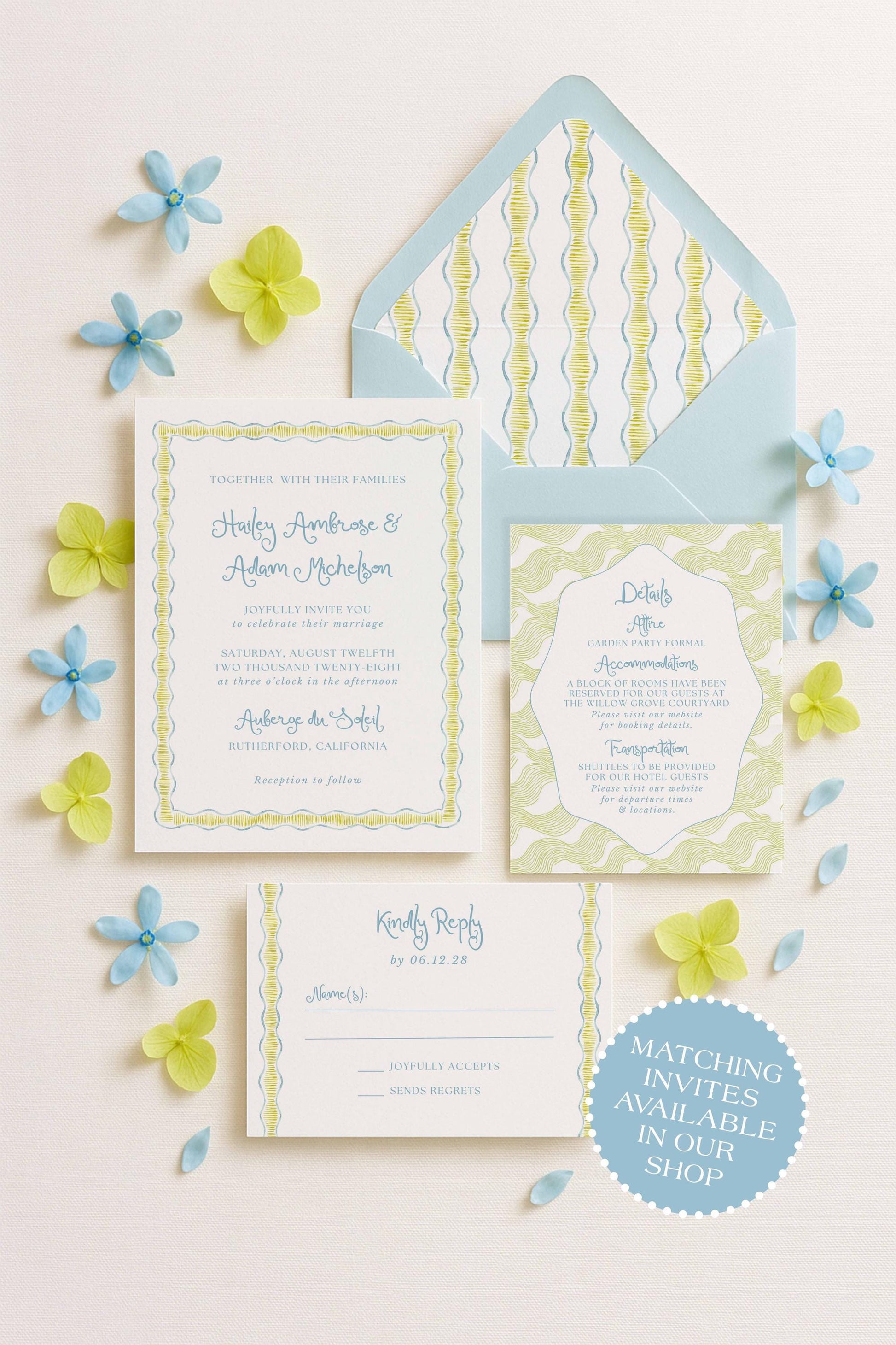 a wedding invitation, an envelope, and a response card, all arranged on a light background with blue and yellow flowers scattered around.